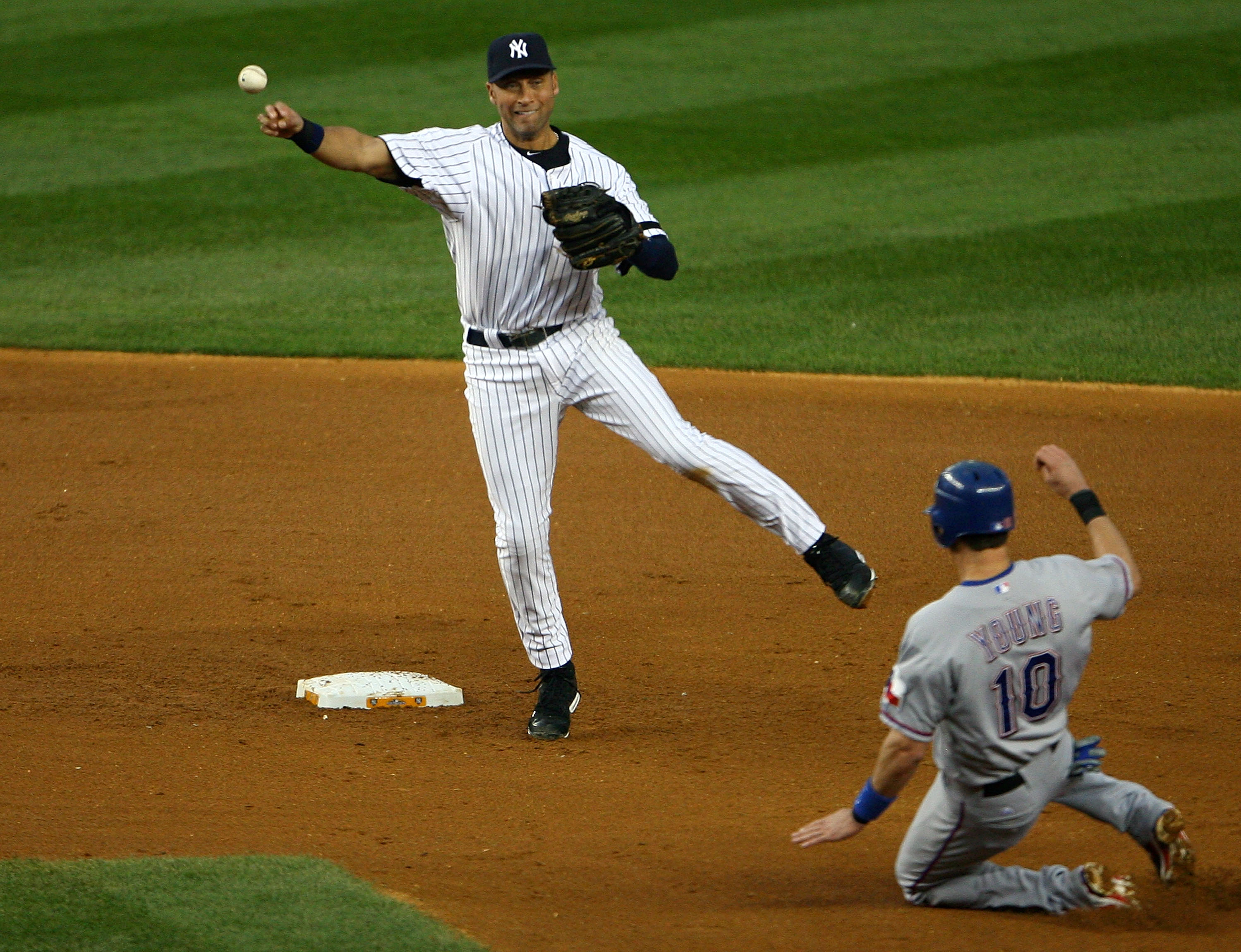 NEW YORK - OCTOBER 20:  Derek Jeter #2 of the New York Yankees turns a successful double play over a sliding Michael Young #10 of the Texas Rangers on a ball hit by Josh Hamilton #32 in the top of the fifth inning of Game Five of the ALCS during the 2010