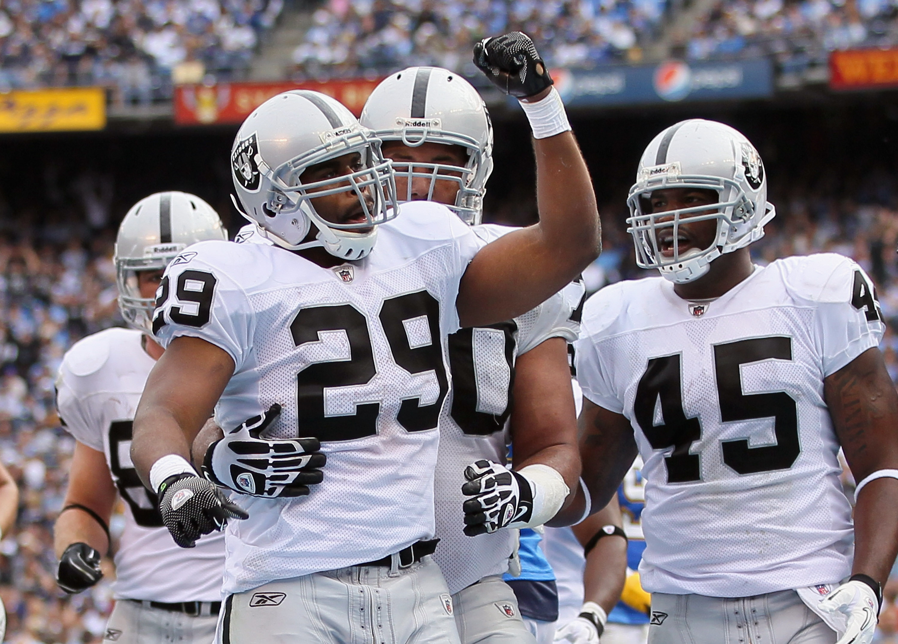 SAN DIEGO - DECEMBER 05:  (L-R) Michael Bush #29, Langston Walker #70 and Marcel Reece #45 of the Oakland Raiders celebrate Bush's touchdown in the second quarter against the San Diego Chargers at Qualcomm Stadium on December 5, 2010 in San Diego, Califor