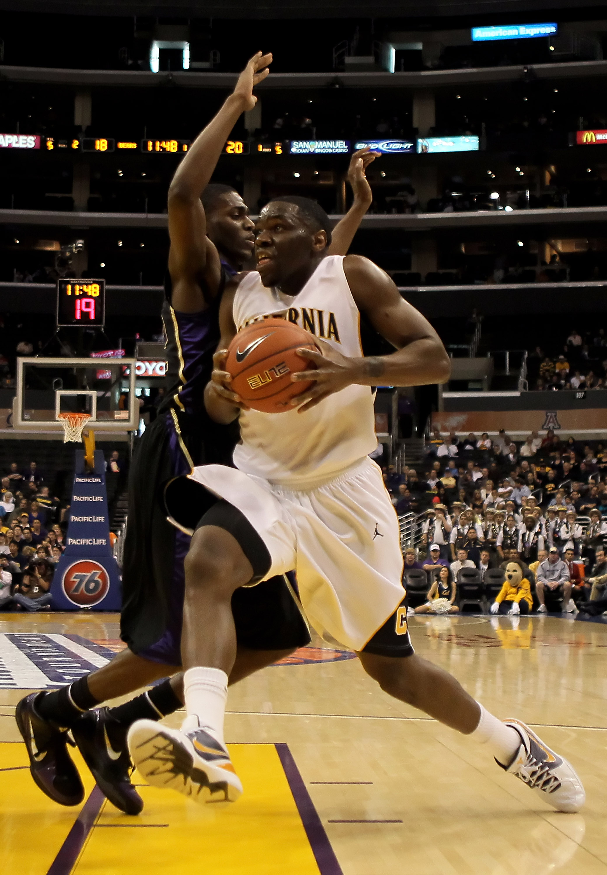 LOS ANGELES, CA - MARCH 13: Theo Robinson #24 of the Cal Golden Bears drives to the basket while being defended by Justin Holiday #22 of the Washington Huskies in the first half during the championship game of the Pac-10 Basketball Tournament at Staples