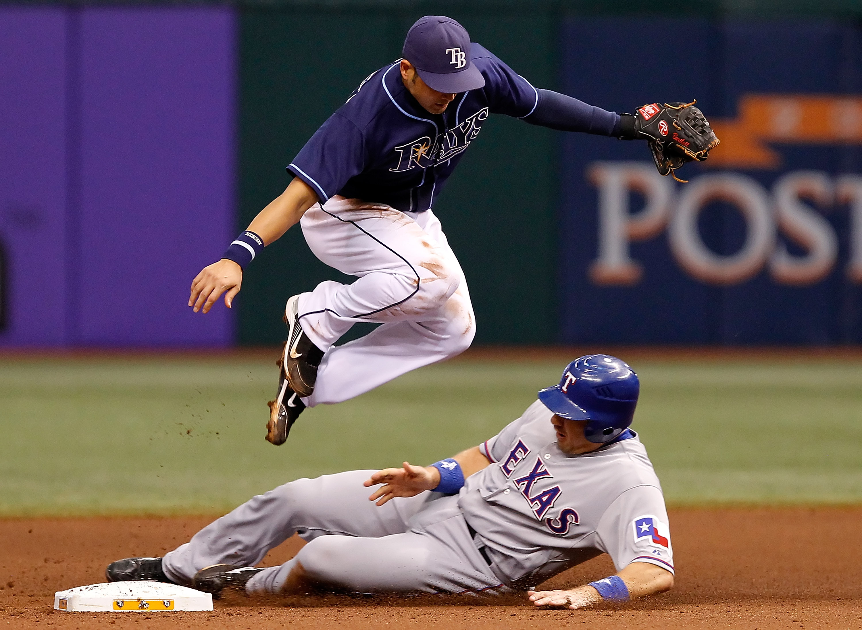 ST. PETERSBURG - OCTOBER 07:  Shortstop Jason Bartlett #8 of the Tampa Bay Rays tries to turn a double play as catcher Matt Treanor #15 of the Texas Rangers is out at second during Game 2 of the ALDS at Tropicana Field on October 7, 2010 in St. Petersburg