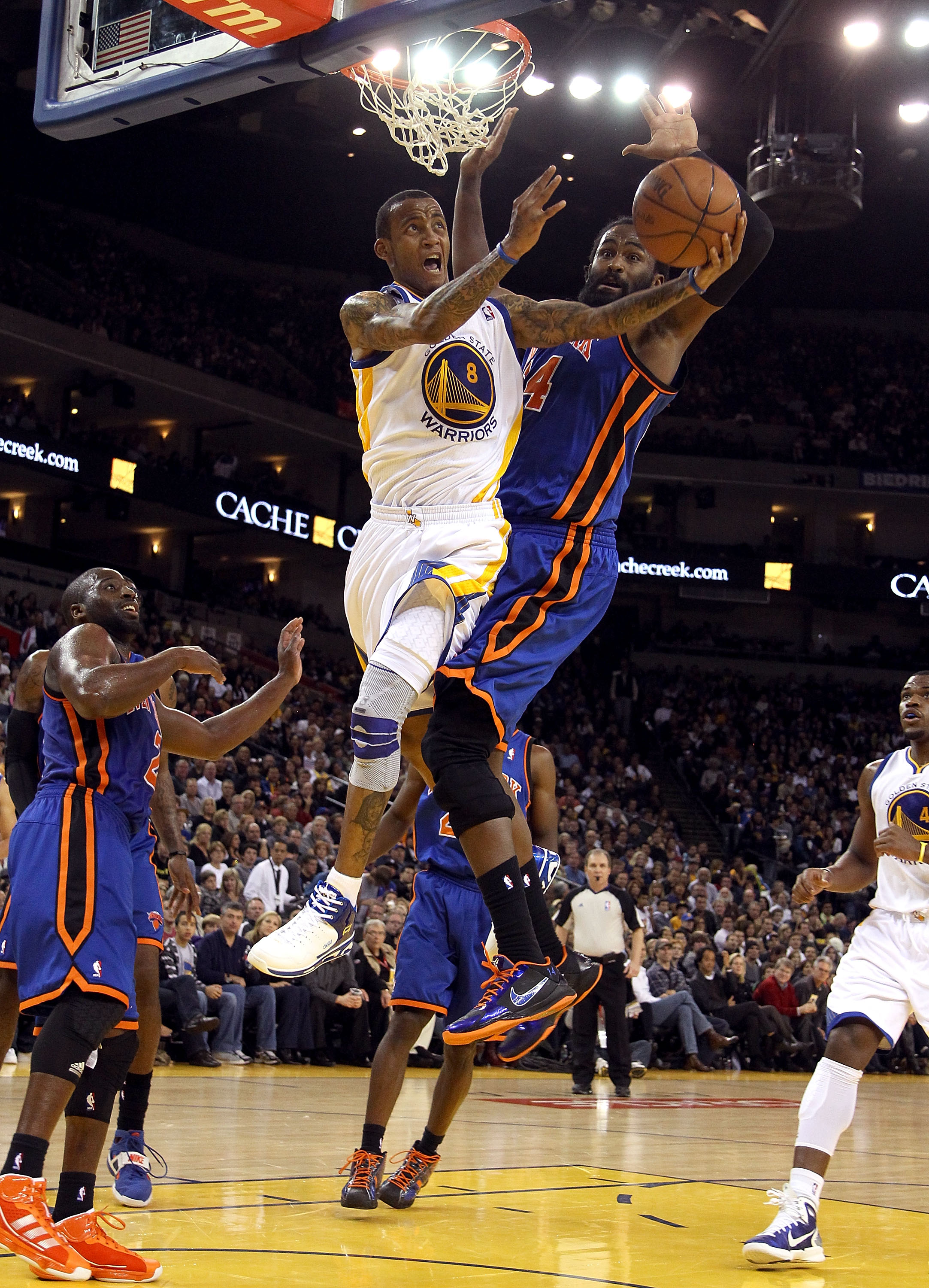 OAKLAND, CA - NOVEMBER 19:  Monta Ellis #8 of the Golden State Warriors goes up for a shot while defended by Ronny Turiaf #14 of the New York Knicks at Oracle Arena on November 19, 2010 in Oakland, California. NOTE TO USER: User expressly acknowledges and
