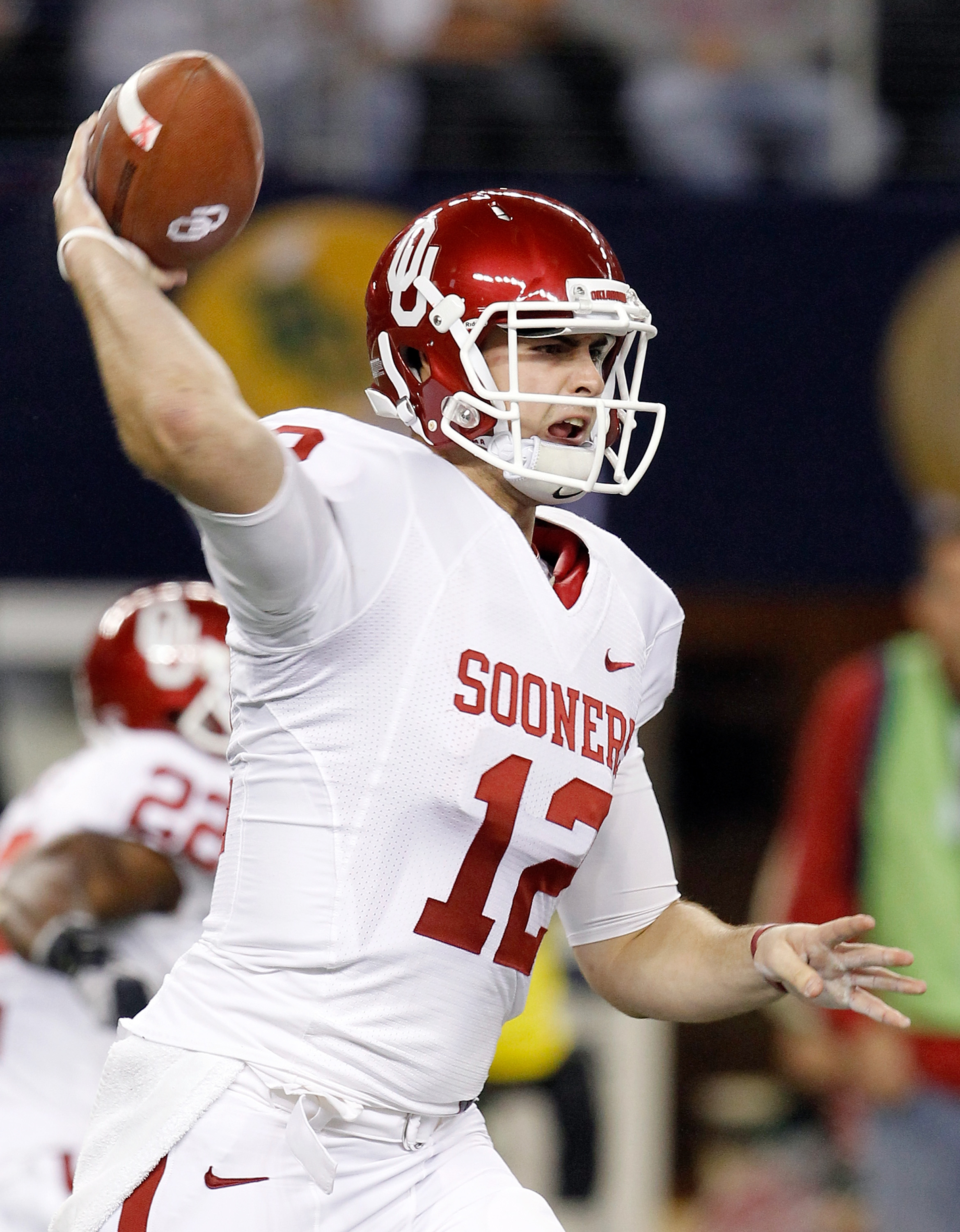 ARLINGTON, TX - DECEMBER 04:  Quarterback Landry Jones #12 of the Oklahoma Sooners looks for an open receiver against the Nebraska Cornhuskers at Cowboys Stadium on December 4, 2010 in Arlington, Texas.  The Sooners beat the Cornhuskers 23-20.  (Photo by