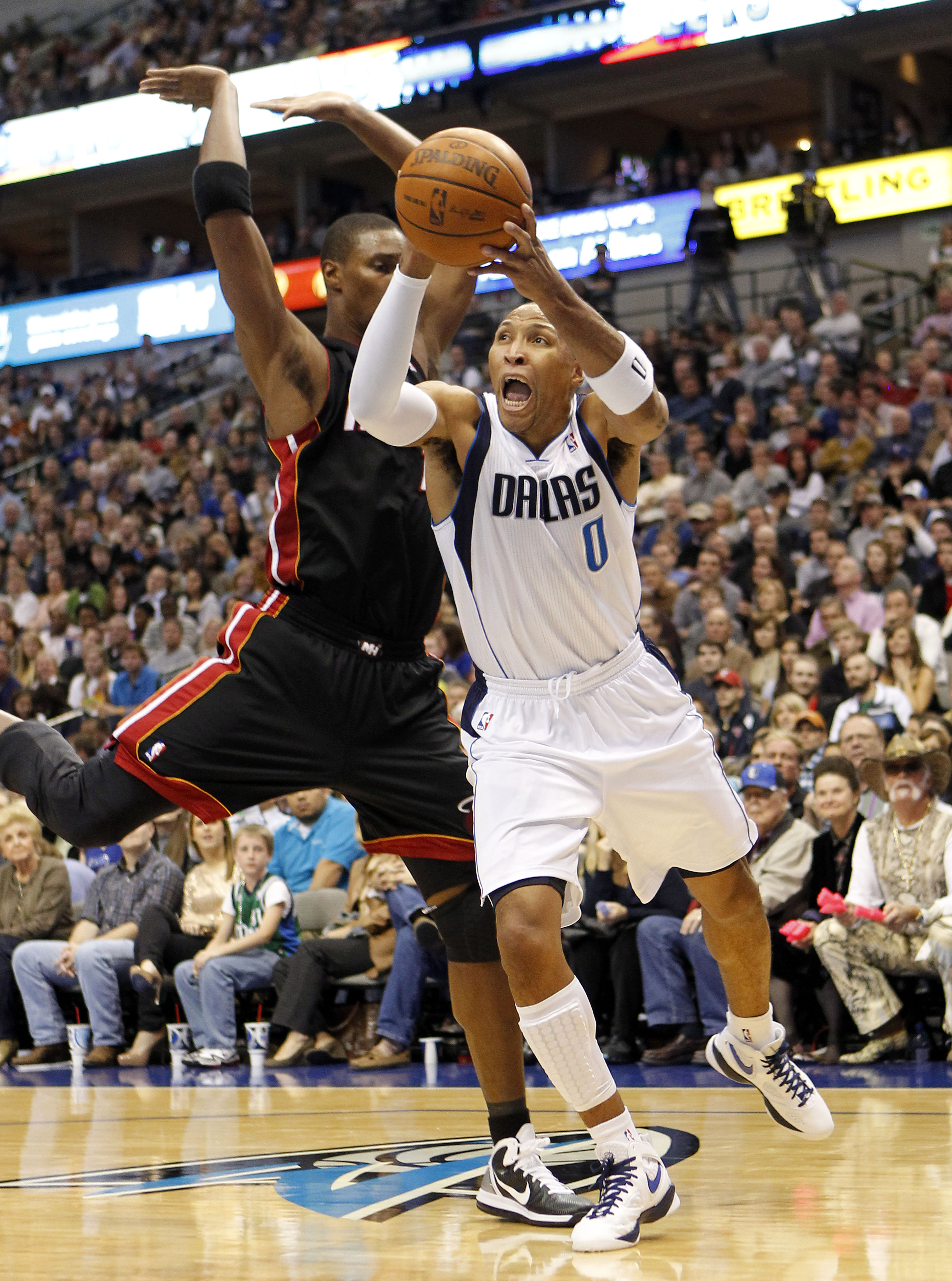 DALLAS - NOVEMBER 27: Shawn Marion #0 of the Dallas Mavericks drives by Chris Bosh #1 of the Miami Heat on November 27, 2010 at the American Airlines Center in Dallas, Texas. NOTE TO USER: User expressly acknowledges and agrees that, by downloading and or
