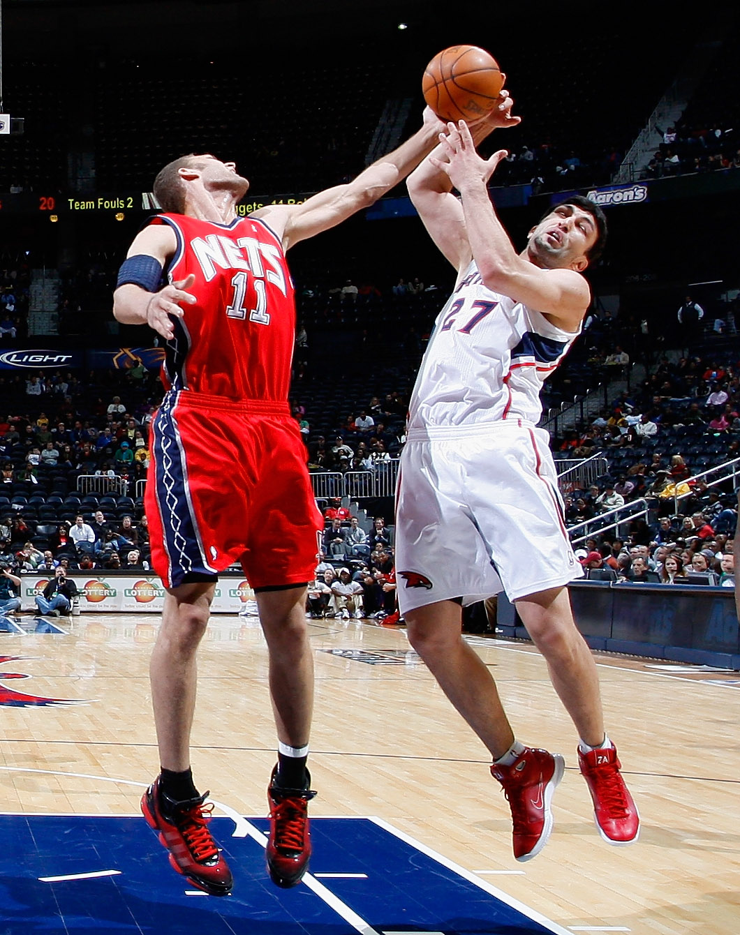 ATLANTA, GA - DECEMBER 07:  Zaza Pachulia #27 of the Atlanta Hawks battles for a rebound against Brook Lopez #11 of the New Jersey Nets at Philips Arena on December 7, 2010 in Atlanta, Georgia.  NOTE TO USER: User expressly acknowledges and agrees that, b