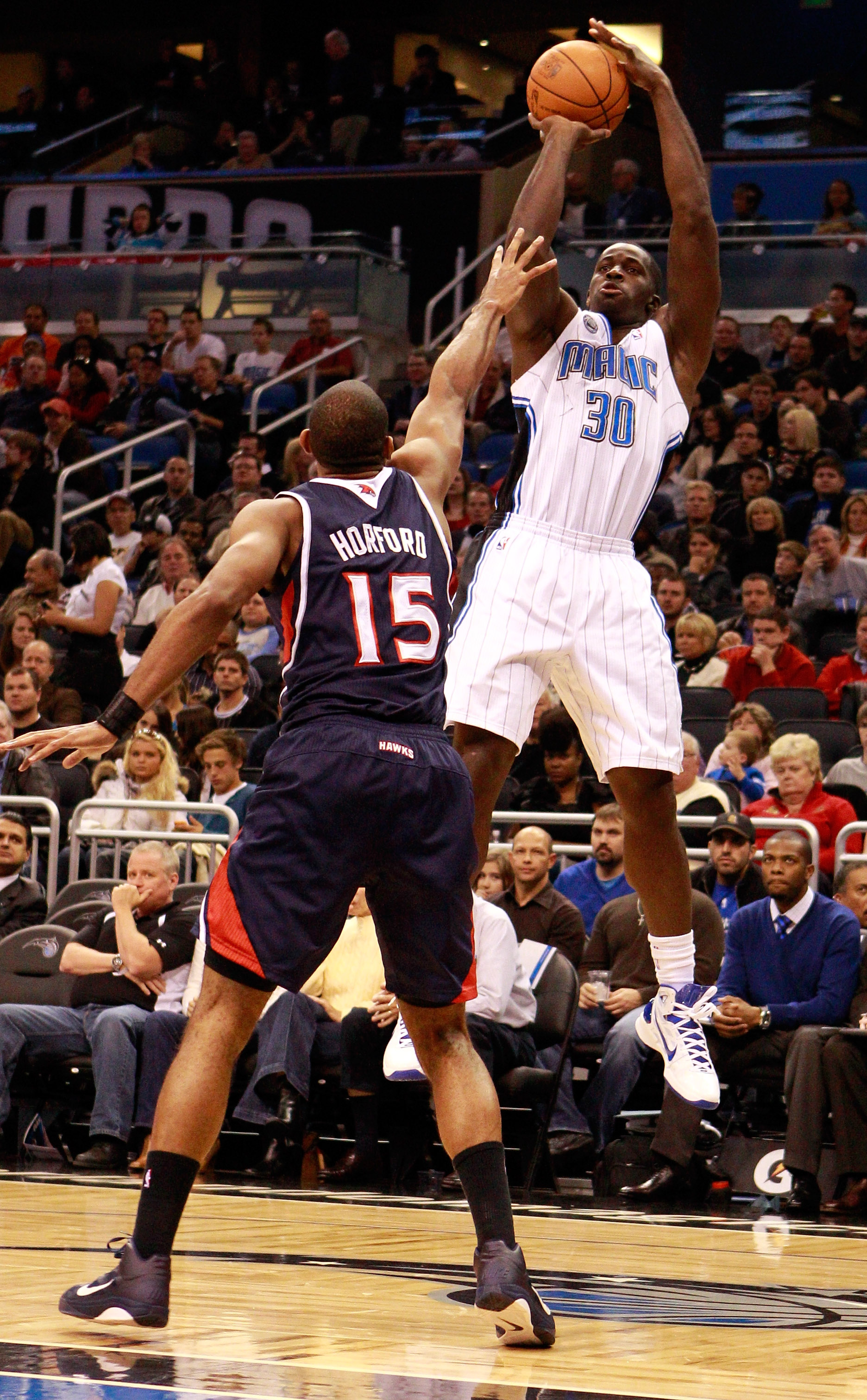 ORLANDO, FL - DECEMBER 06:  Brandon Bass #30 of the Orlando Magic attempts a shot over Al Hoford #15 of the Atlanta Hawks during the game at Amway Arena on December 6, 2010 in Orlando, Florida. NOTE TO USER: User expressly acknowledges and agrees that, by