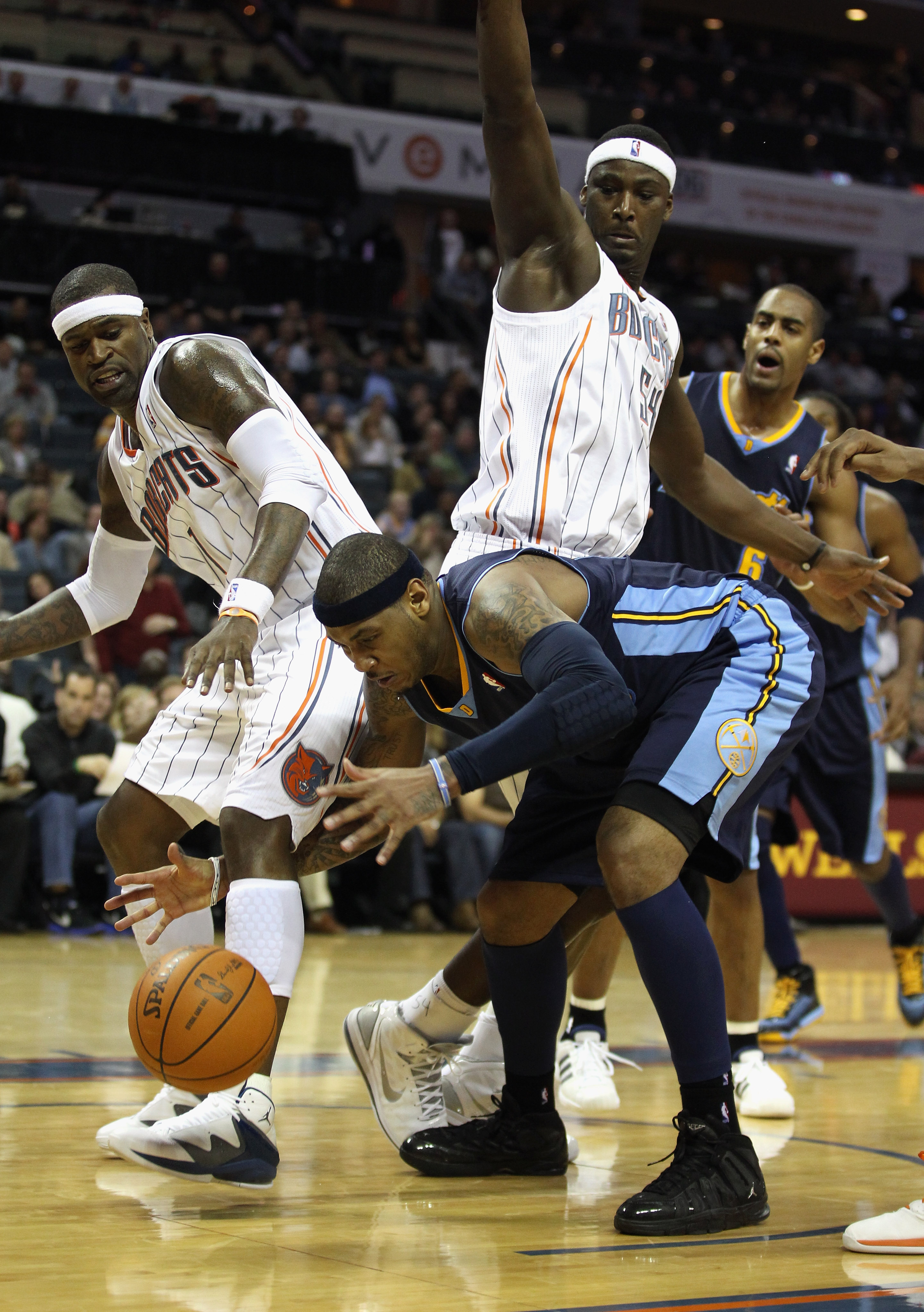 CHARLOTTE, NC - DECEMBER 07:  Carmelo Anthony #15 of the Denver Nuggets battles for a loose ball with Stephen Jackson #1 of the Charlotte Bobcats during their game at Time Warner Cable Arena on December 7, 2010 in Charlotte, North Carolina.  NOTE TO USER: