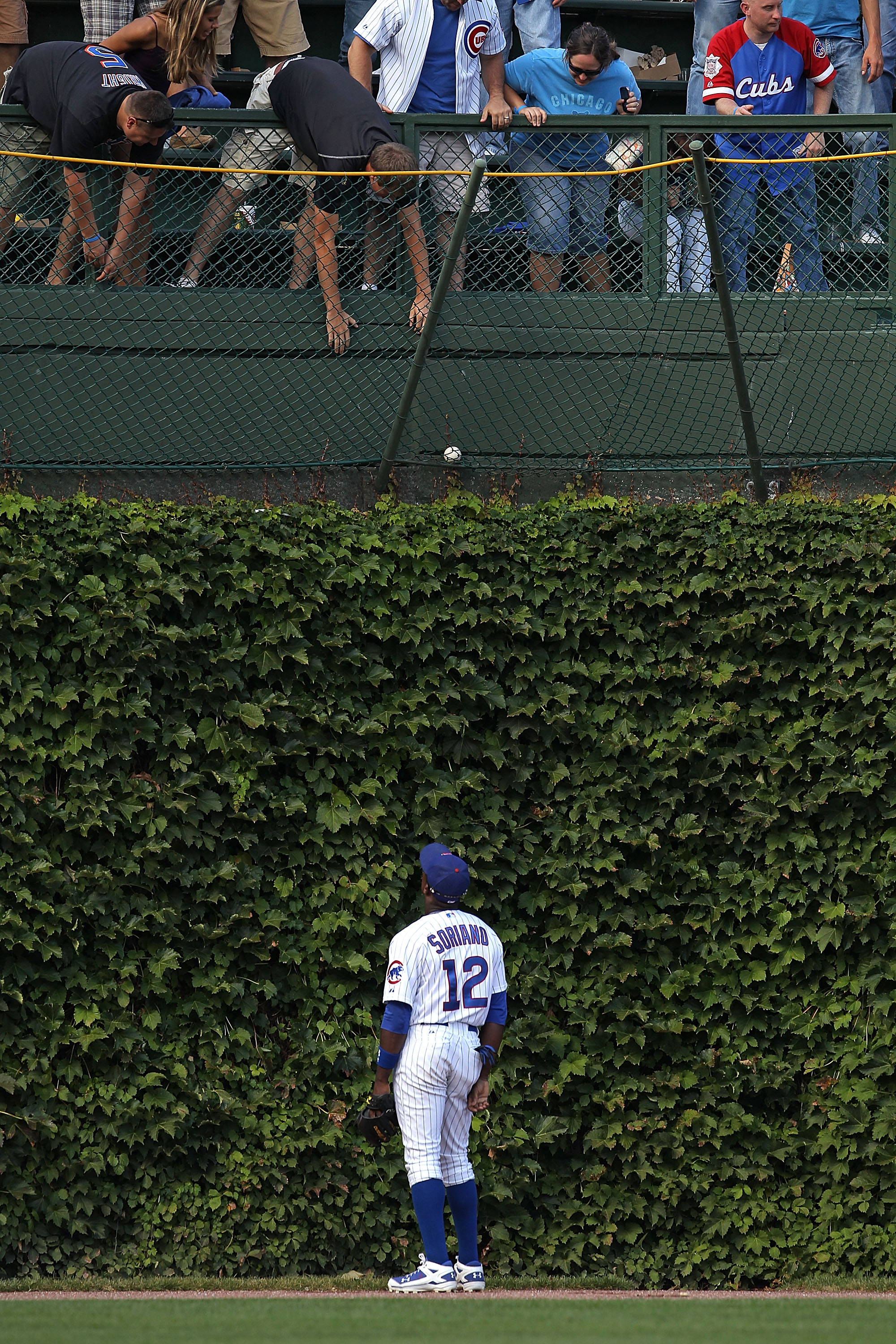CHICAGO - SEPTEMBER 05: Alfonso Soriano #12 of the Chicago Cubs watches as fans try to grab a home run ball hit by Ike Davis of the New York Mets out of the basket in left field at Wrigley Field on September 5, 2010 in Chicago, Illinois. (Photo by Jonatha