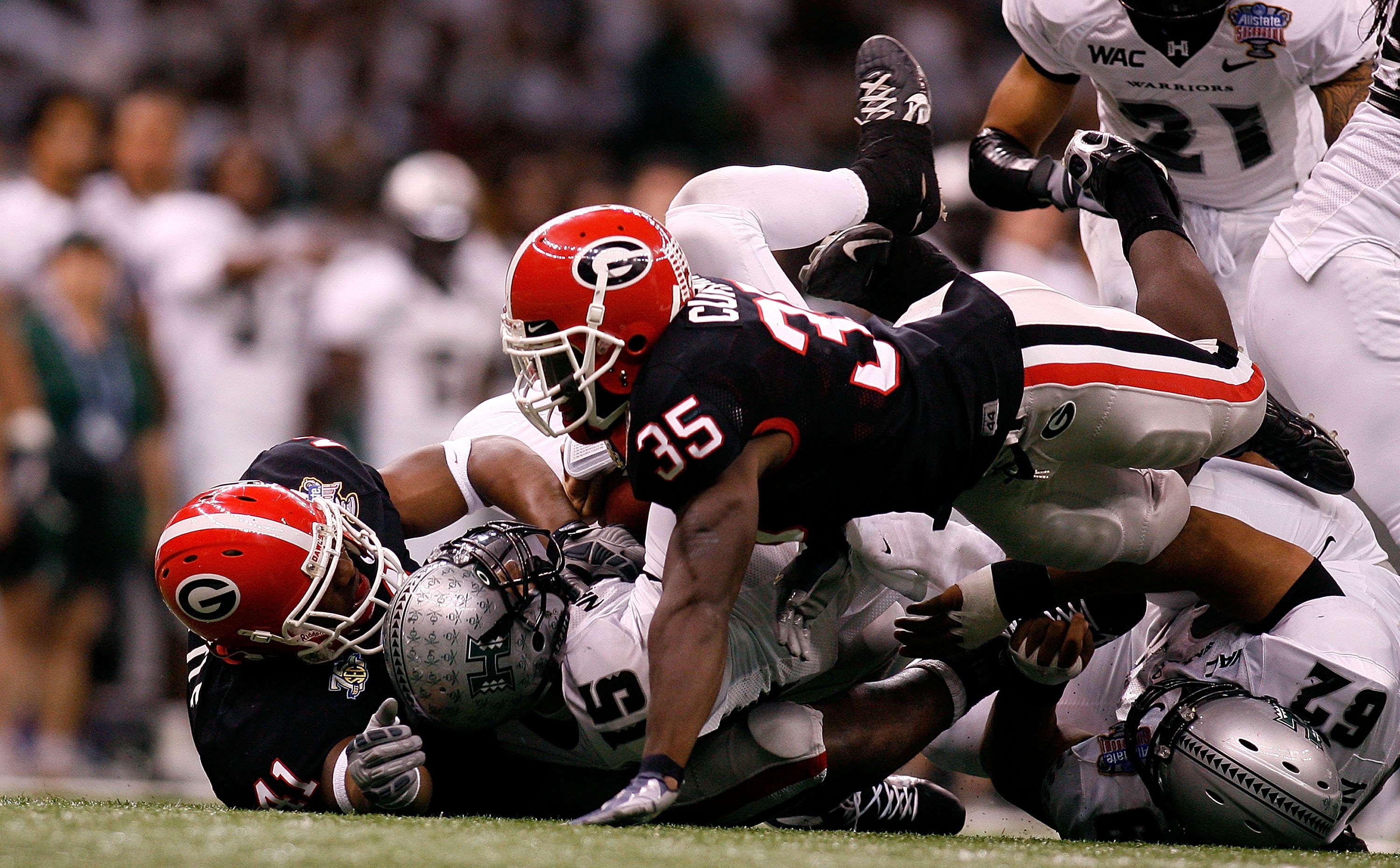 NEW ORLEANS - JANUARY 01: Colt Brennan #15 of the Hawai'i Warriors is sacked by Roderick Battle #41 and Rennie Curran #35 of the Georgia Bulldogs during the Allstate Sugar Bowl at the Louisiana Superdome on January 1, 2008 in New Orleans, Louisiana. Geor