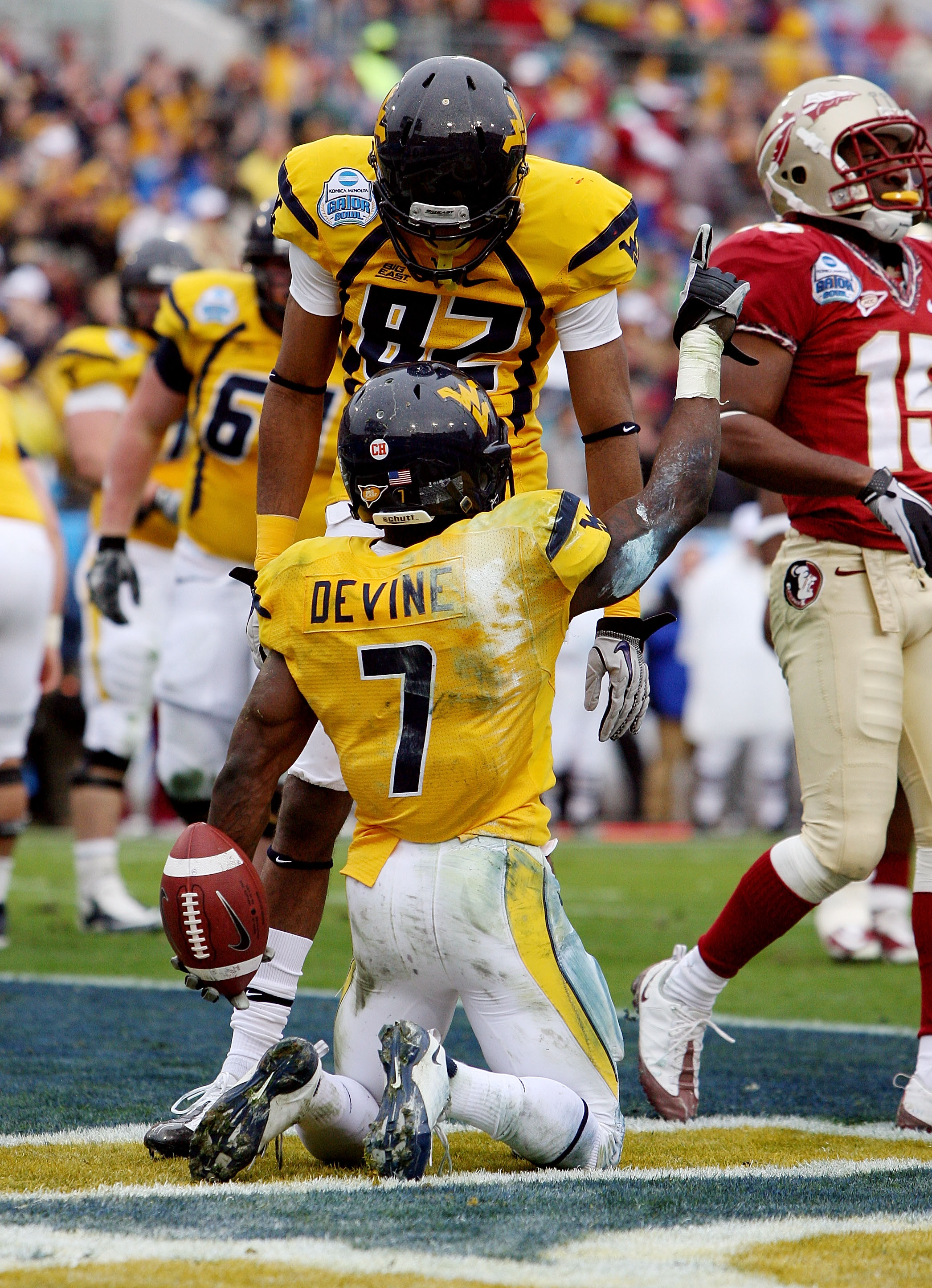 JACKSONVILLE, FL - JANUARY 01: Running back Noel Devine #7 and wide receiver Alric Arnett #82 of the West Virginia Mountaineers celebrate Devine's first quarter touchdown in the first quarter against the Florida State Seminoles during the Konica Minolta G
