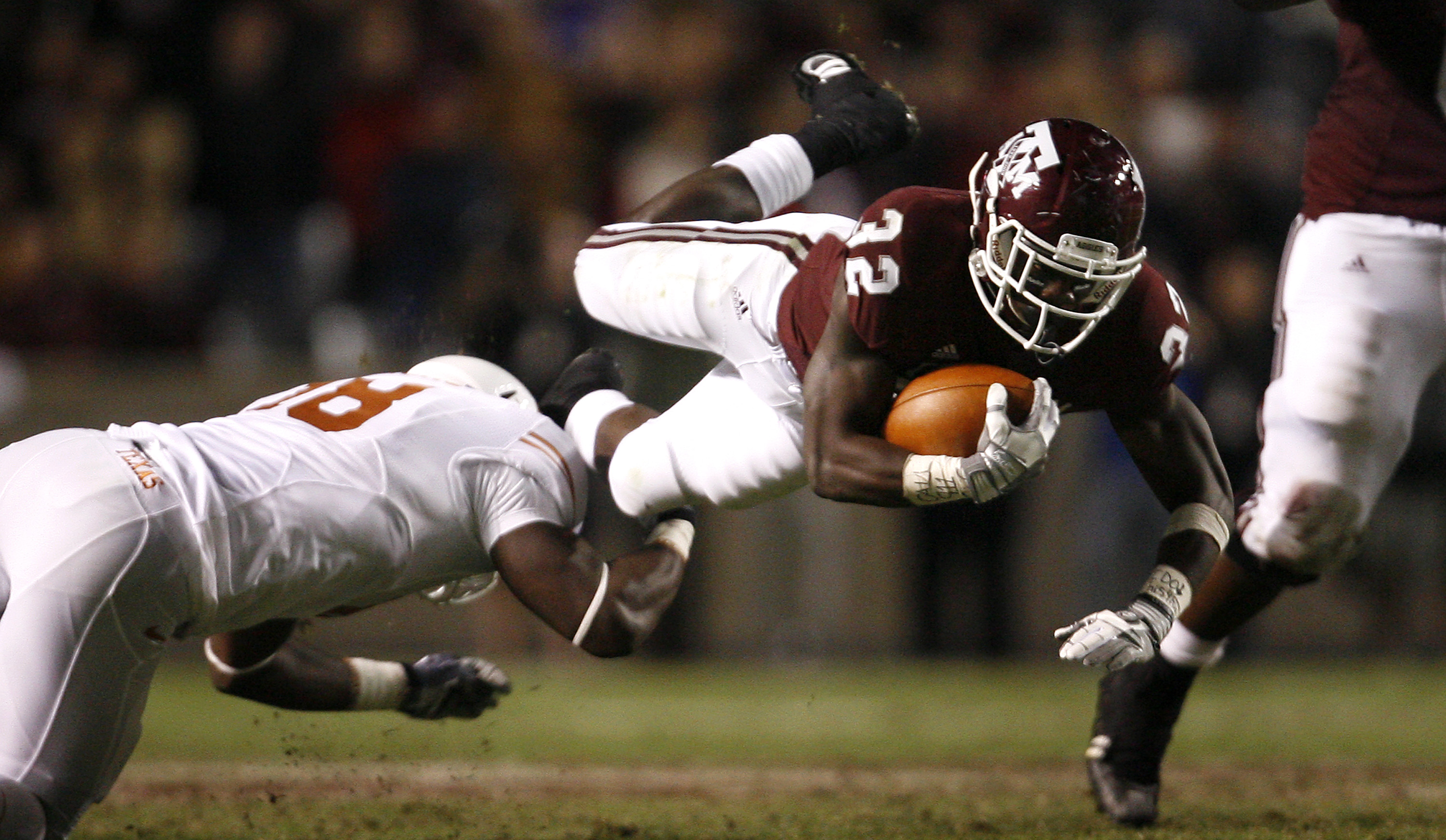 COLLEGE STATION, TX - NOVEMBER 26: Tailback Cyrus Gray #32 of the Texas A&M Aggies is tripped up by a Texas Longhorns defender in the second half at Kyle Field on November 26, 2009 in College Station, Texas. The Longhorns defeated the Aggies 49-39. (Photo