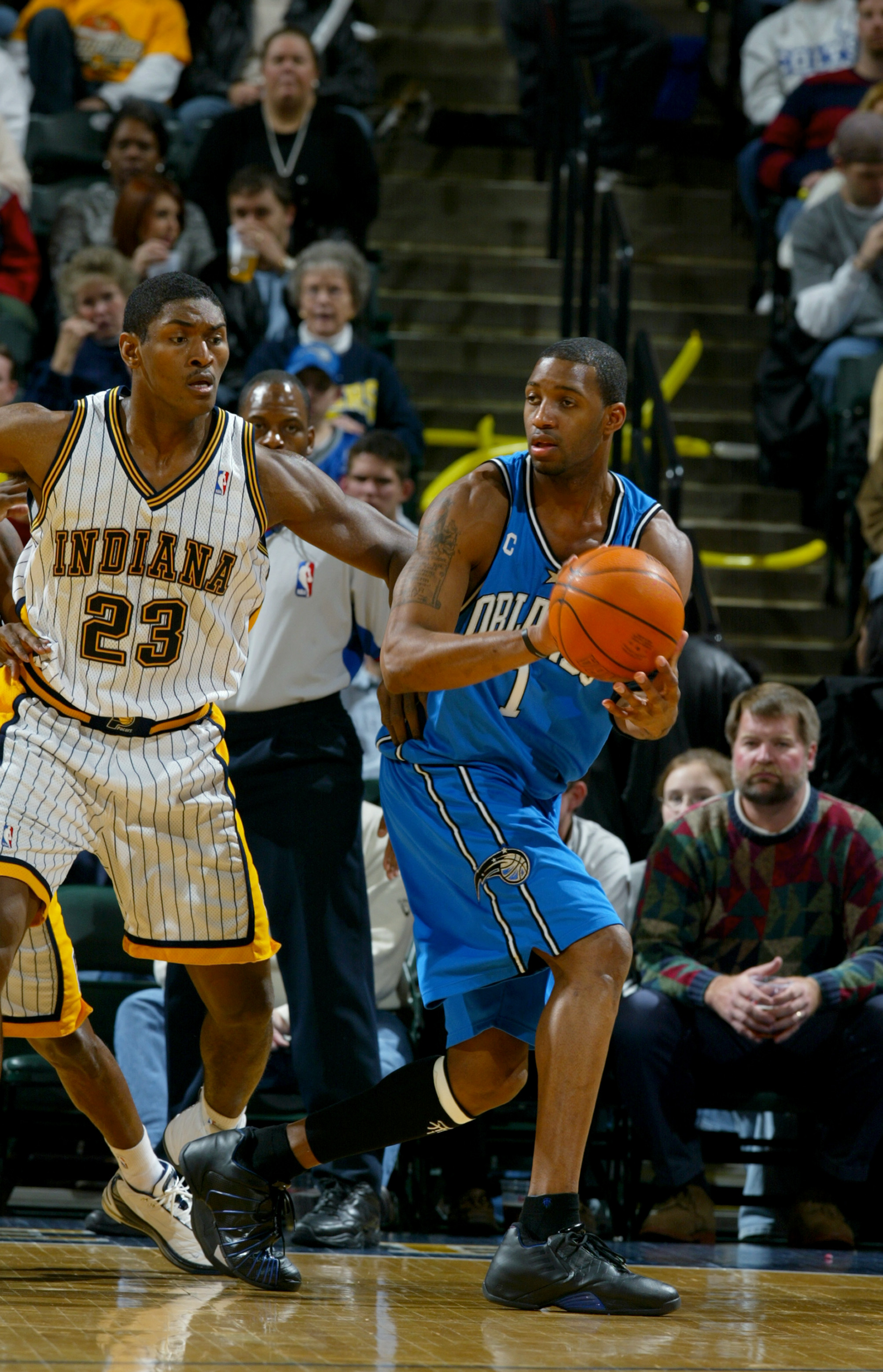 INDIANAPOLIS - DECEMBER 17:  Tracy McGrady #1 of the Orlando Magic looks to pass as he is covered by Ron Artest #23 of the Indiana Pacers on December 17, 2003 at Conseco Fieldhouse in Indianapolis, Indiana.  The Magic won 94-90.  NOTE TO USER: User expres