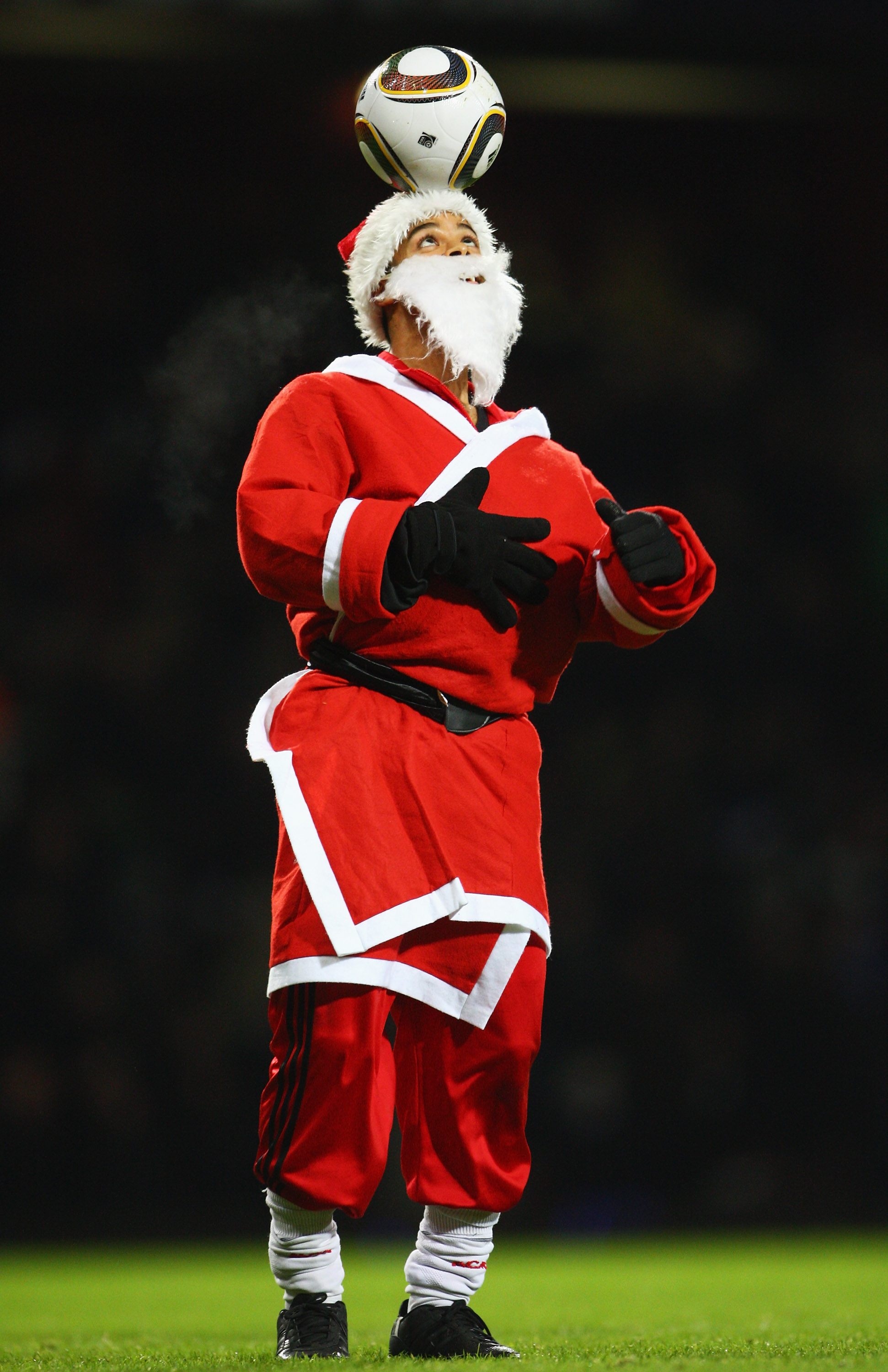 LONDON, ENGLAND - DECEMBER 20:  A ball juggler dressed as Father Christmas displays his skills at half time during the Barclays Premier League match between West Ham United and Chelsea at Upton Park on December 20, 2009 in London, England.  (Photo by Phil