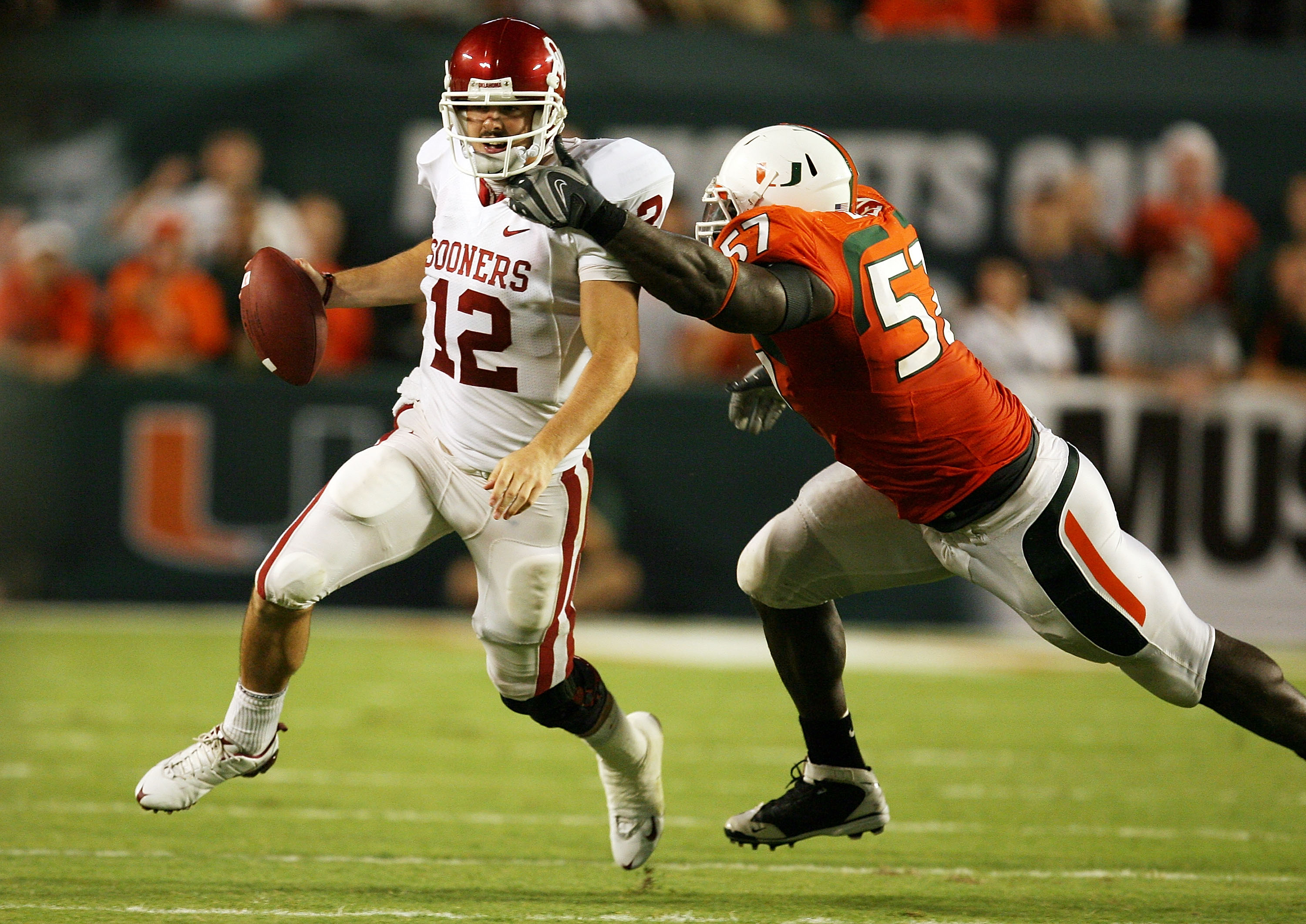 FORT LAUDERDALE, FL - OCTOBER 03: Quarterback Landry Jones #12 of the Oklahoma Sooners is sacked by defensive lineman Allen Bailey #57 of the Miami Hurricanes knocked down a pass attempt at Land Shark Stadium on October 3, 2009 in Fort Lauderdale, Florida