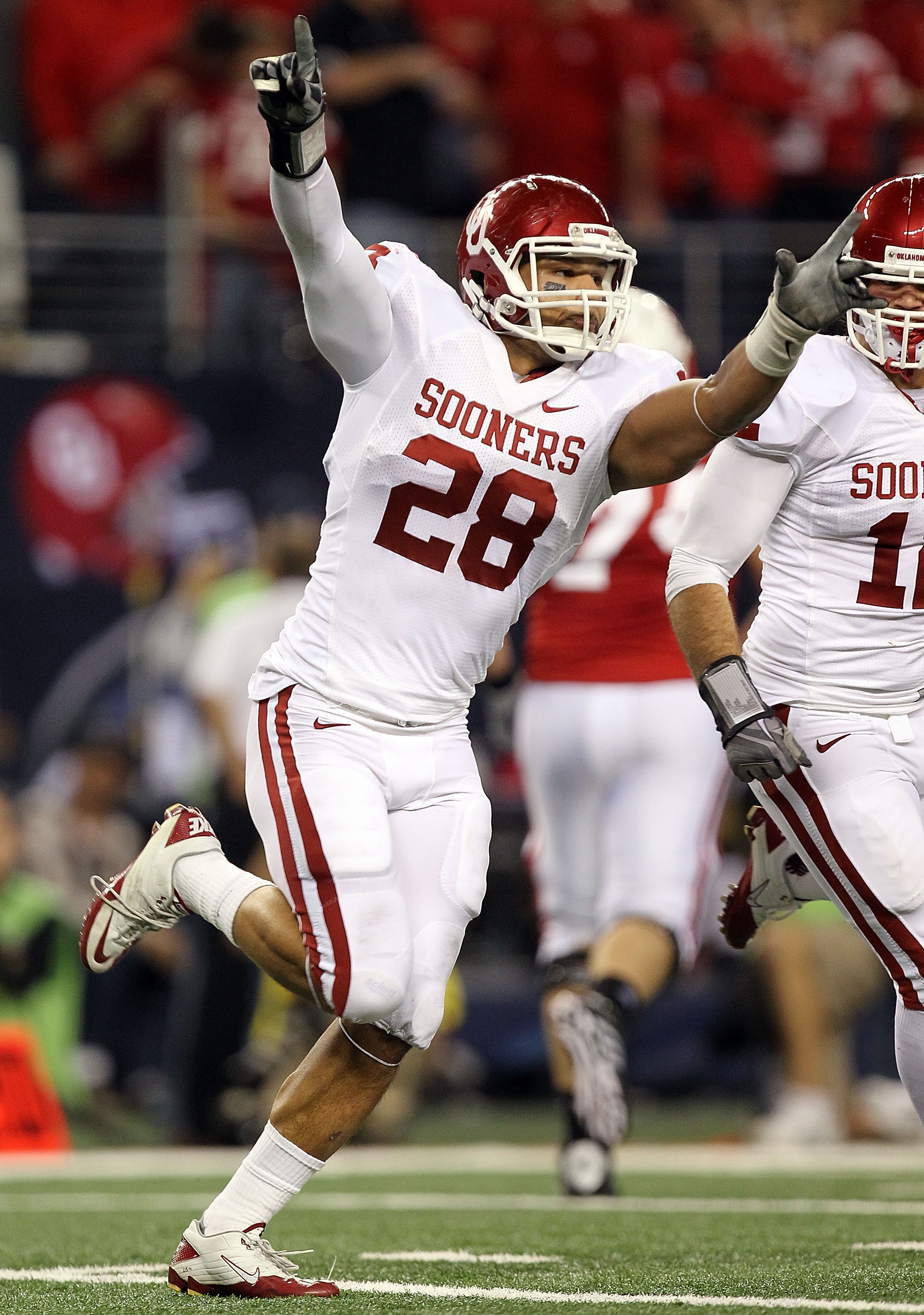ARLINGTON, TX - DECEMBER 04:  Linebacker Travis Lewis #28 of the Oklahoma Sooners celebrate a pass interception against the Nebraska Cornhuskers during the Big 12 Championship at Cowboys Stadium on December 4, 2010 in Arlington, Texas.  (Photo by Ronald M
