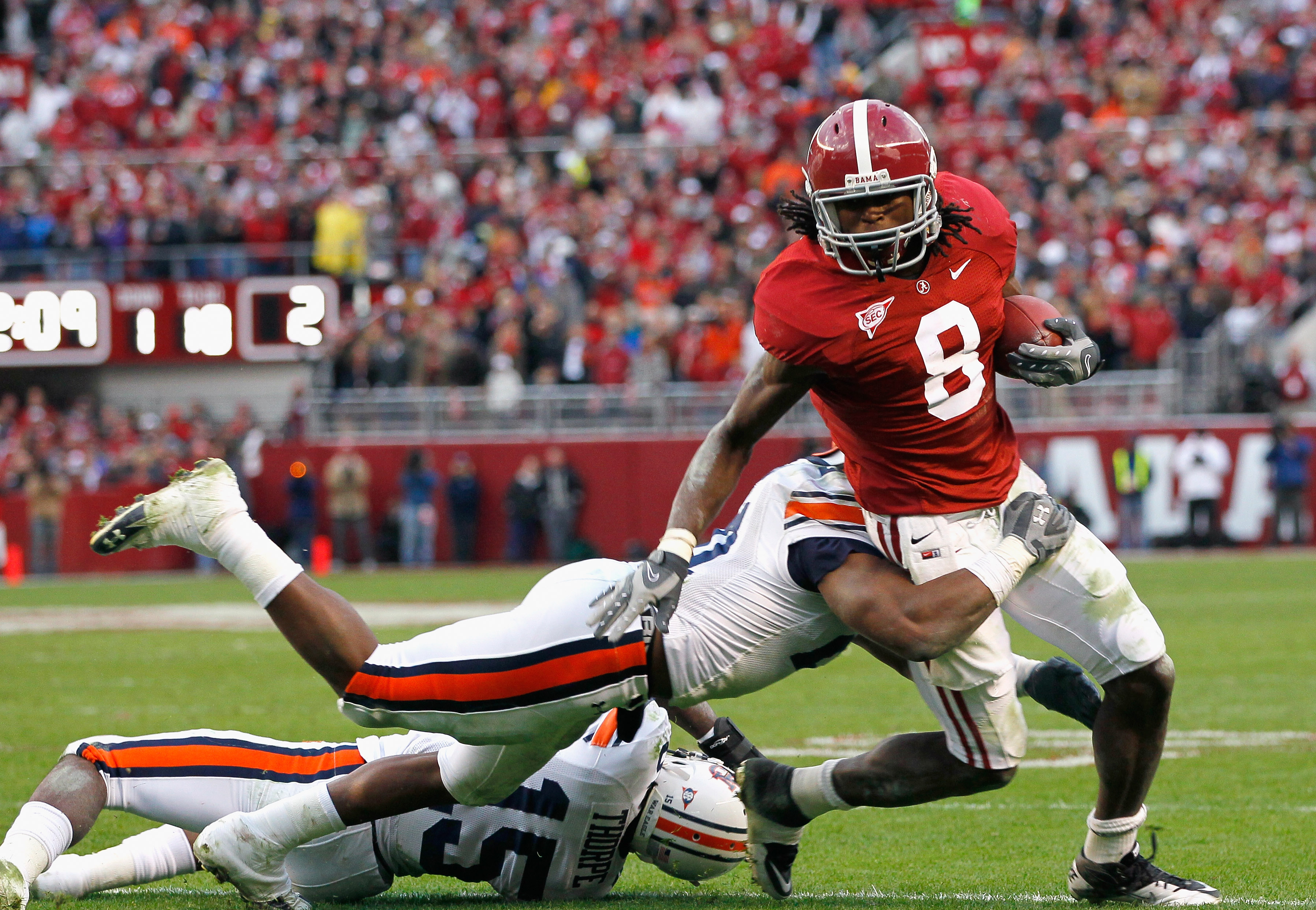 TUSCALOOSA, AL - NOVEMBER 26:  Julio Jones #8 of the Alabama Crimson Tide is tackled by Neiko Thorpe #15 and Eltoro Freeman #21 of the Auburn Tigers at Bryant-Denny Stadium on November 26, 2010 in Tuscaloosa, Alabama.  (Photo by Kevin C. Cox/Getty Images)