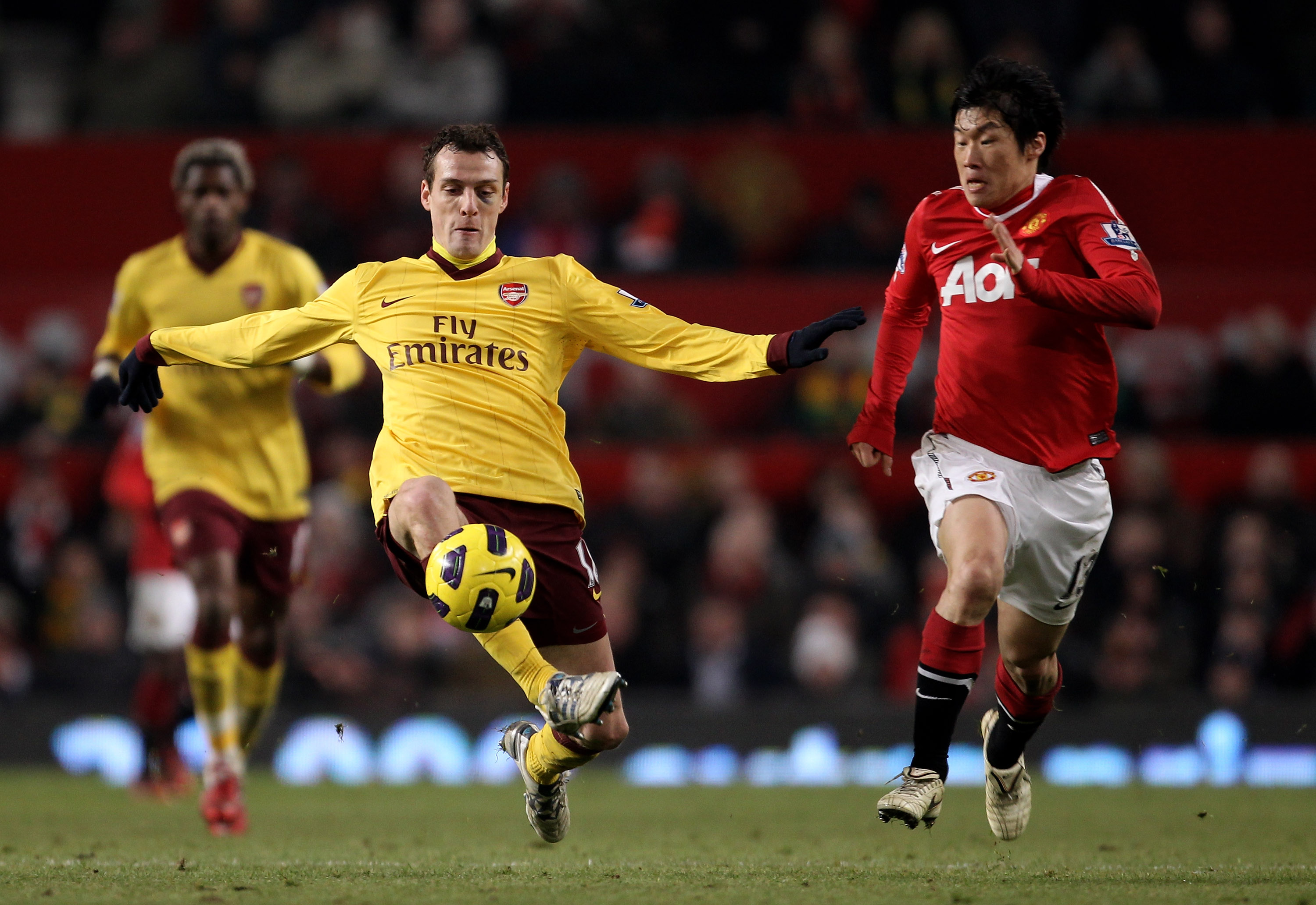 MANCHESTER, ENGLAND - DECEMBER 13:  Sebastian Squillaci of Arsenal competes with Ji-Sung Park of Manchester United during the Barclays Premier League match between Manchester United and Arsenal at Old Trafford on December 13, 2010 in Manchester, England.