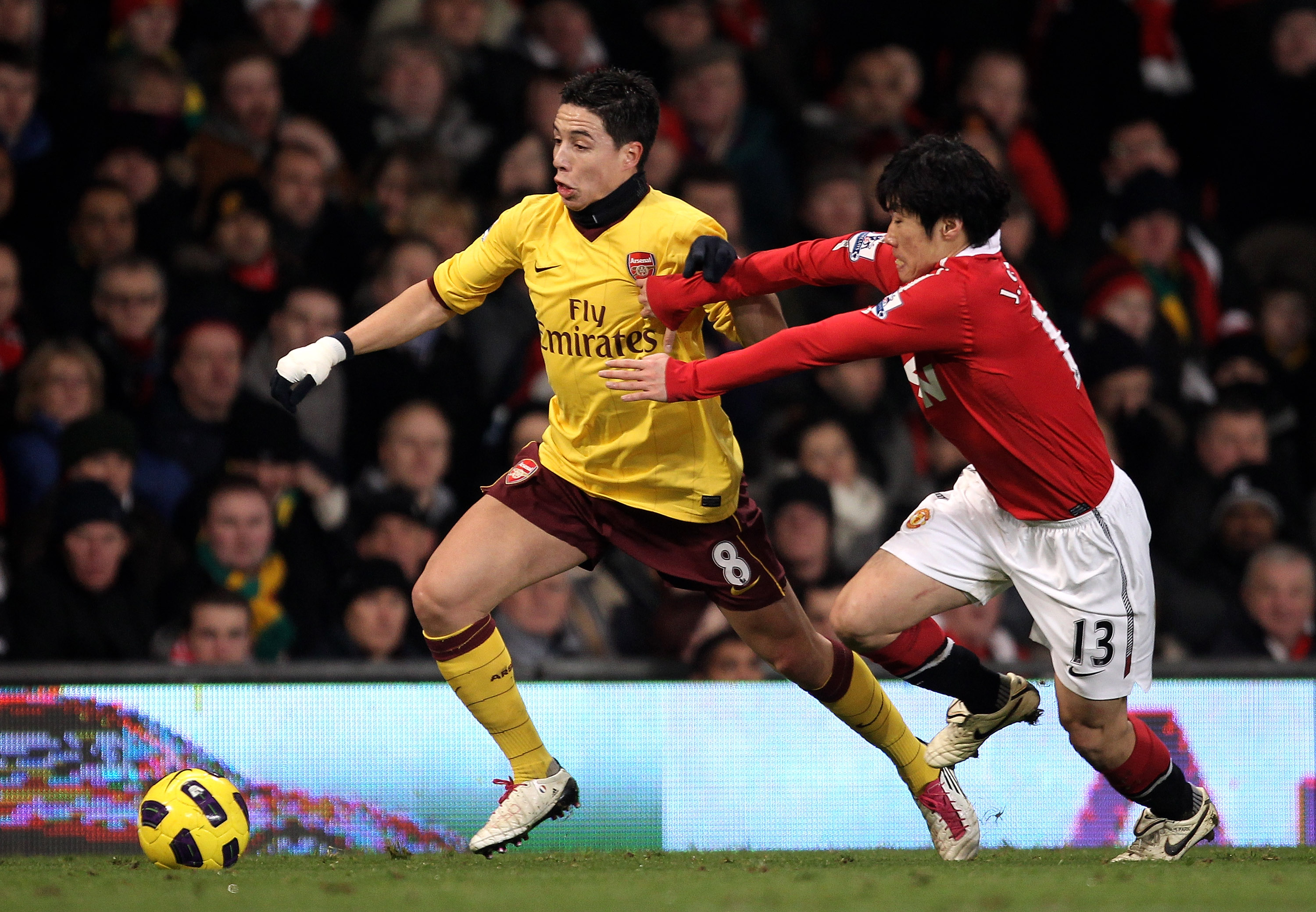 MANCHESTER, ENGLAND - DECEMBER 13:  Samir Nasri of Arsenal is challenged by Ji-Sung Park of Manchester United during the Barclays Premier League match between Manchester United and Arsenal at Old Trafford on December 13, 2010 in Manchester, England.  (Pho