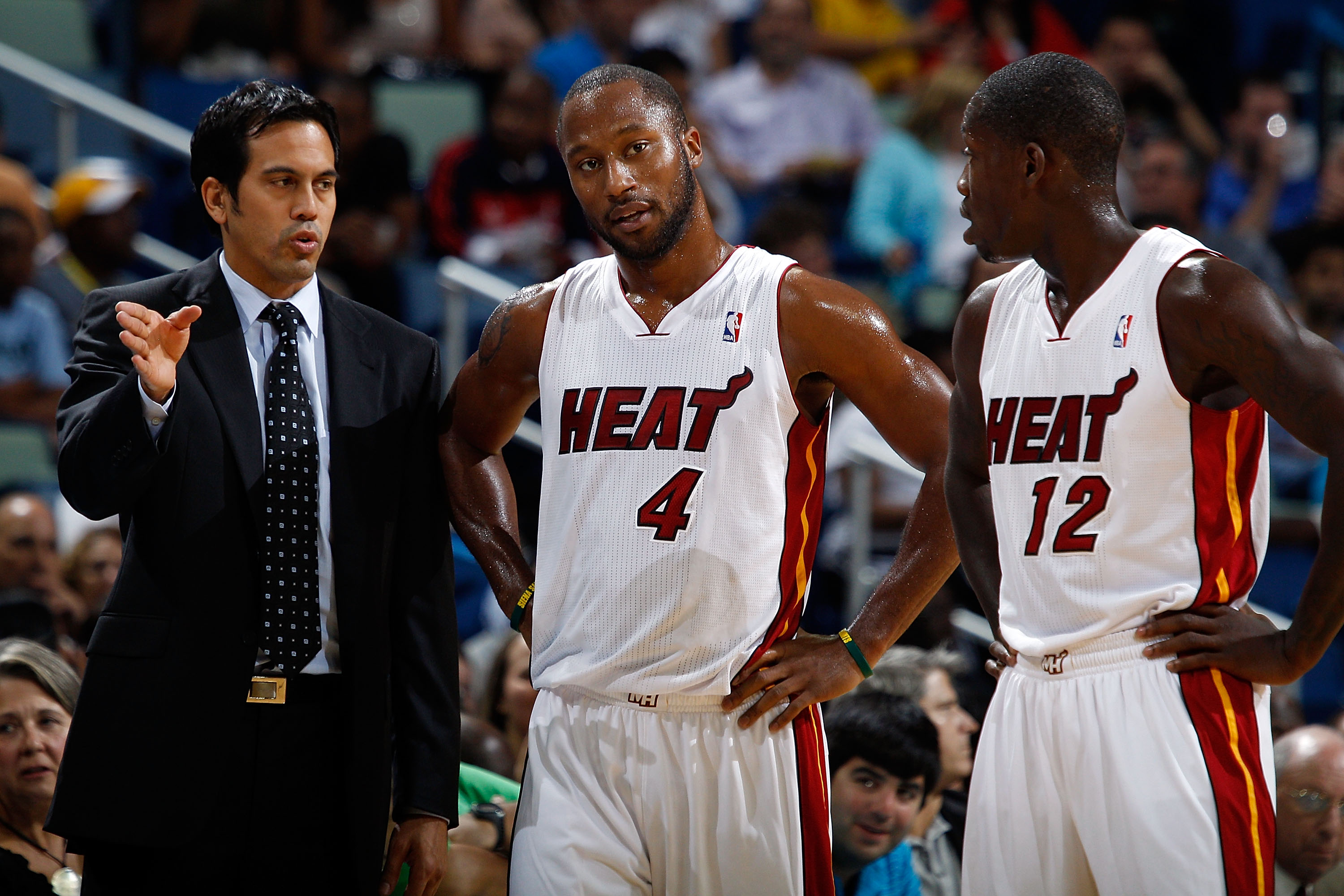 NEW ORLEANS - OCTOBER 13:  Head coach Erik Spoelstra talks with Kenny Hasbrouck #4 and Patrick Beverley #12 of the Miami Heat during the game against the New Orleans Hornets at the New Orleans Arena on October 13, 2010 in New Orleans, Louisiana.  NOTE TO