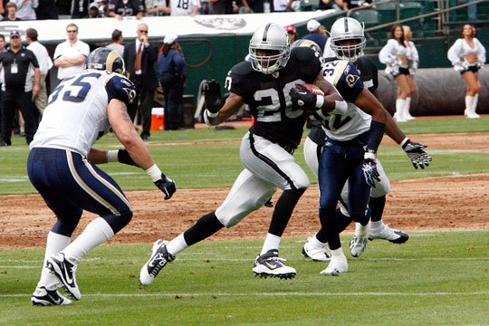 Oakland Raiders running back Darren McFadden (20) pushes off of Kansas City  Chiefs safety Jarrad Page (44) during the first half of an NFL football  game Sunday, Sept. 20, 2009, in Kansas