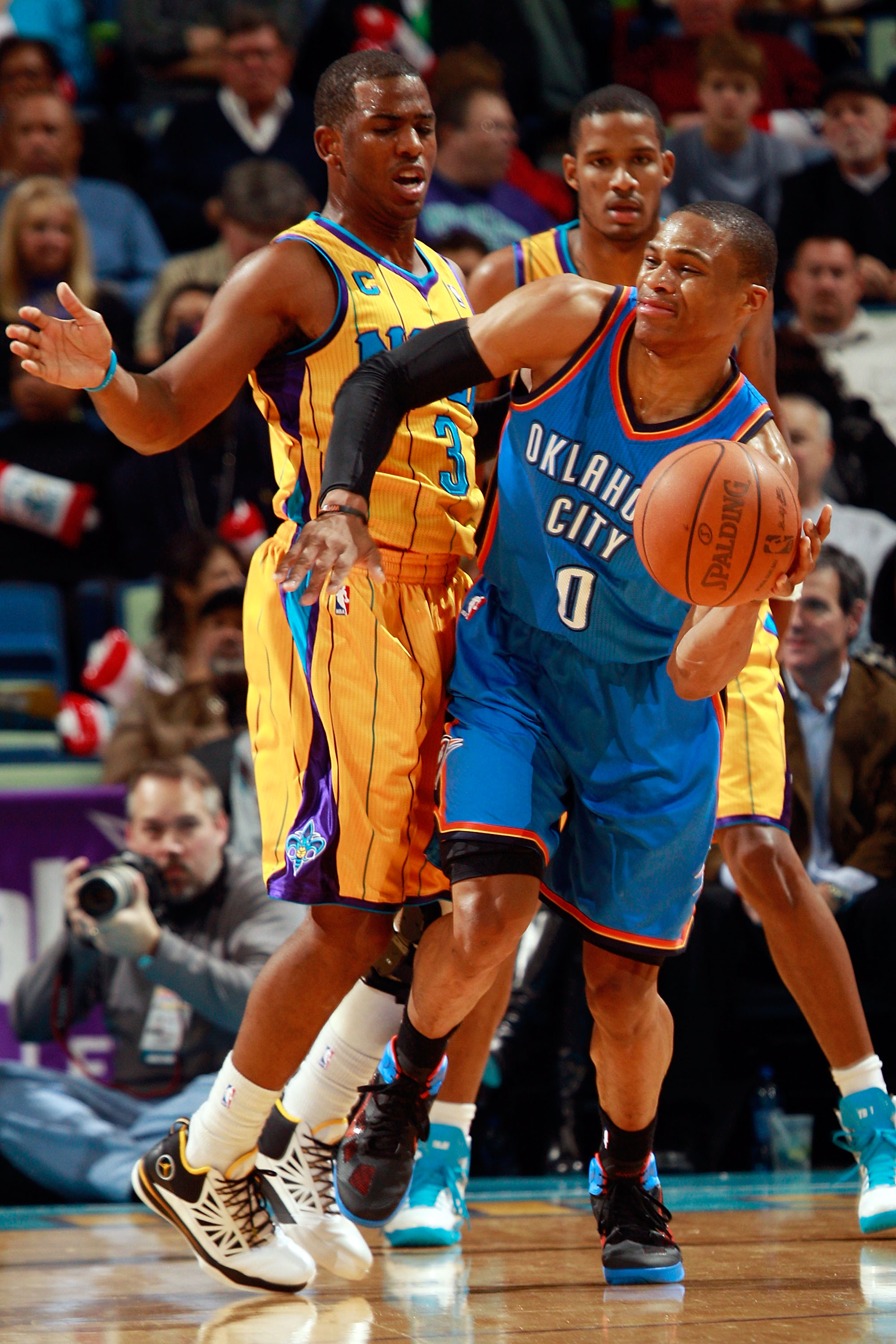 NEW ORLEANS, LA - DECEMBER 10:  Russell Westbrook #0 of the Oklahoma City Thunder passes the ball around Chris Paul #3 of the New Orleans Hornets  at New Orleans Arena on December 10, 2010 in New Orleans, Louisiana.    The Thunder defeated the Hornets 97-