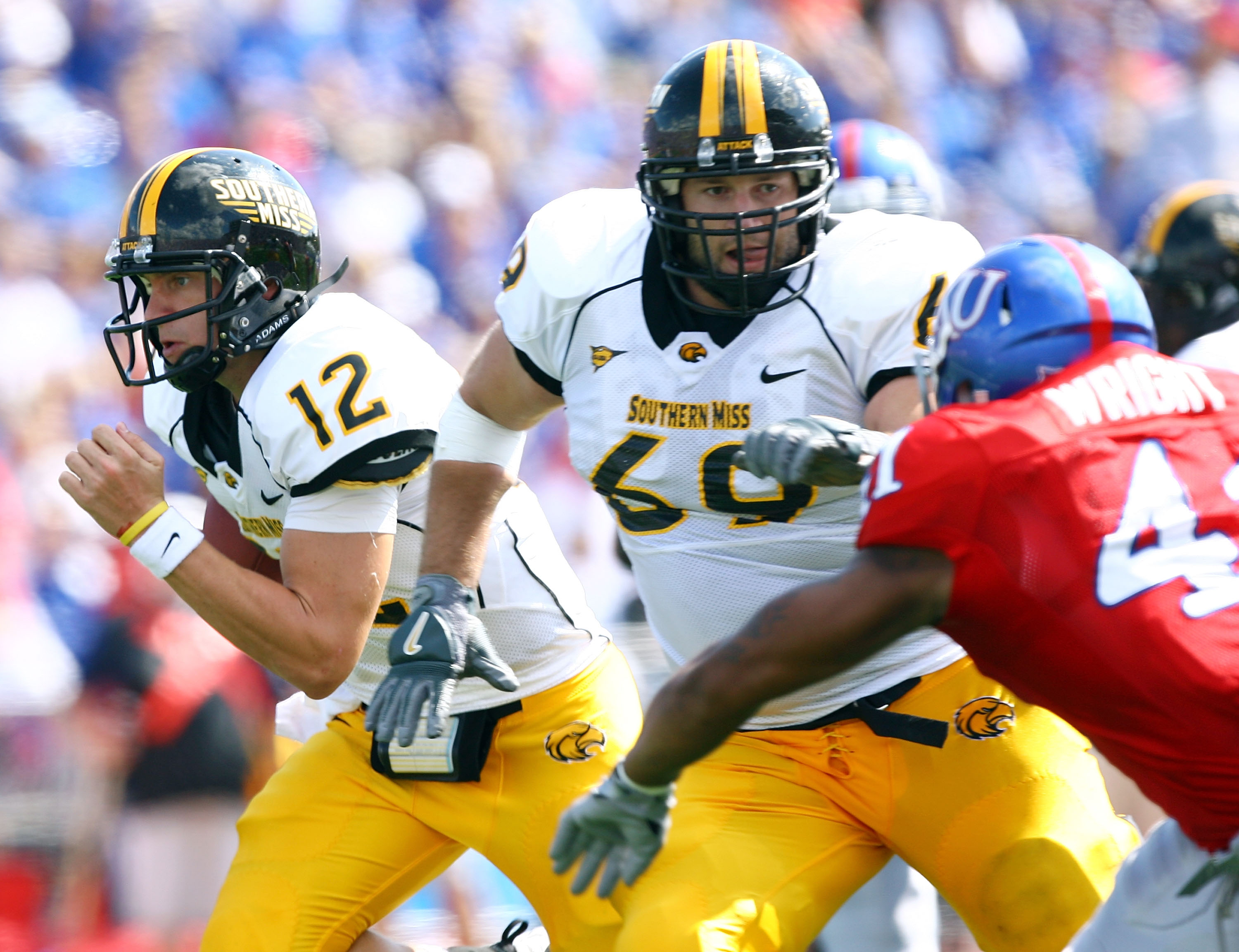 LAWRENCE, KS - SEPTEMBER 26:  Quarterback Austin Davis #12 of the Southern Mississippi Golden Eagles scrambles as Micah Brown #69 throws a block during the game against the Kansas Jayhawks on September 26, 2009 at Memorial Stadium in Lawrence, Kansas.  (P