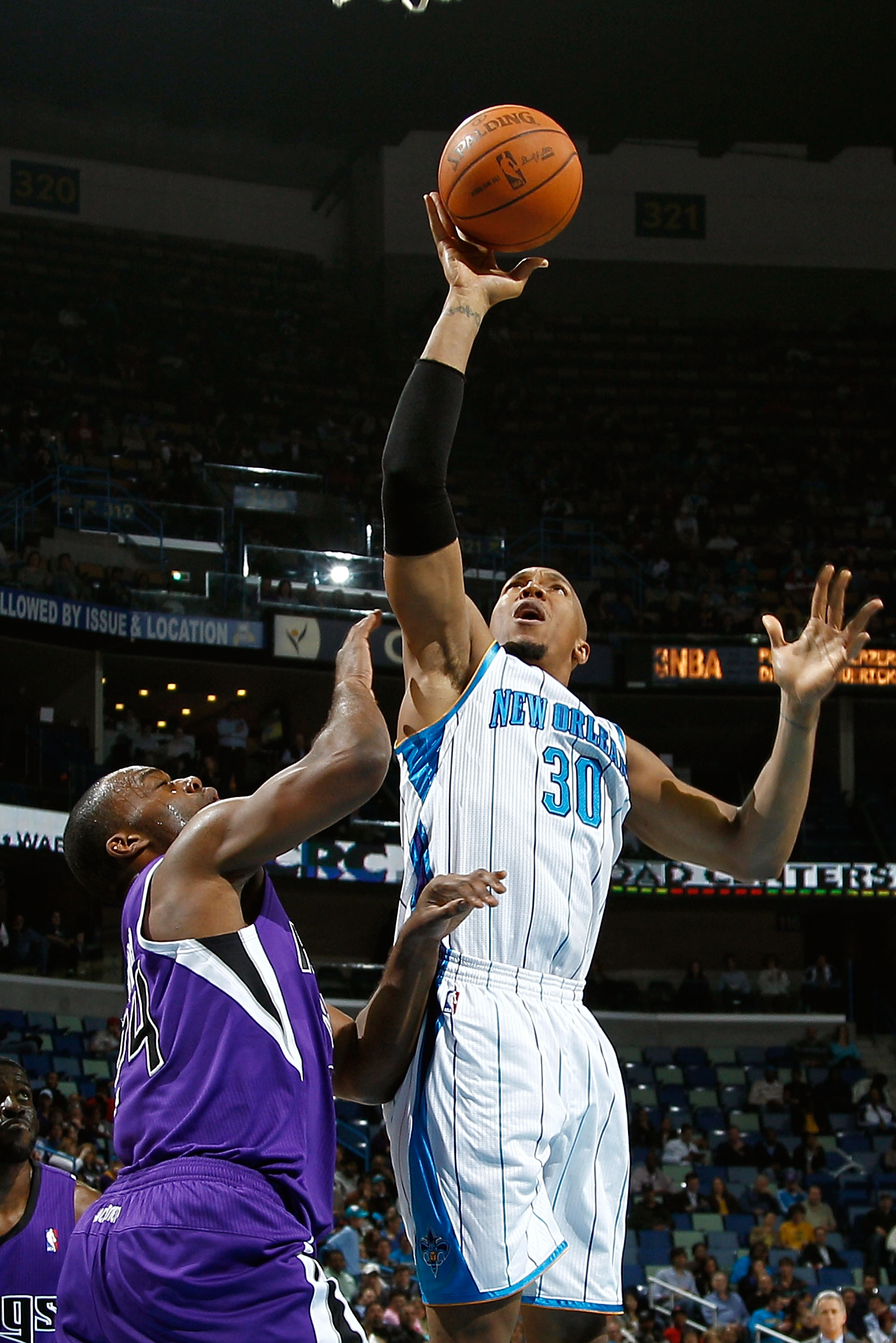 NEW ORLEANS, LA - DECEMBER 15:  David West #30 of the New Orleans Hornets shoots the ball over Carl Landry #24 of the Sacramento Kings at the New Orleans Arena on December 15, 2010 in New Orleans, Louisiana.  NOTE TO USER: User expressly acknowledges and
