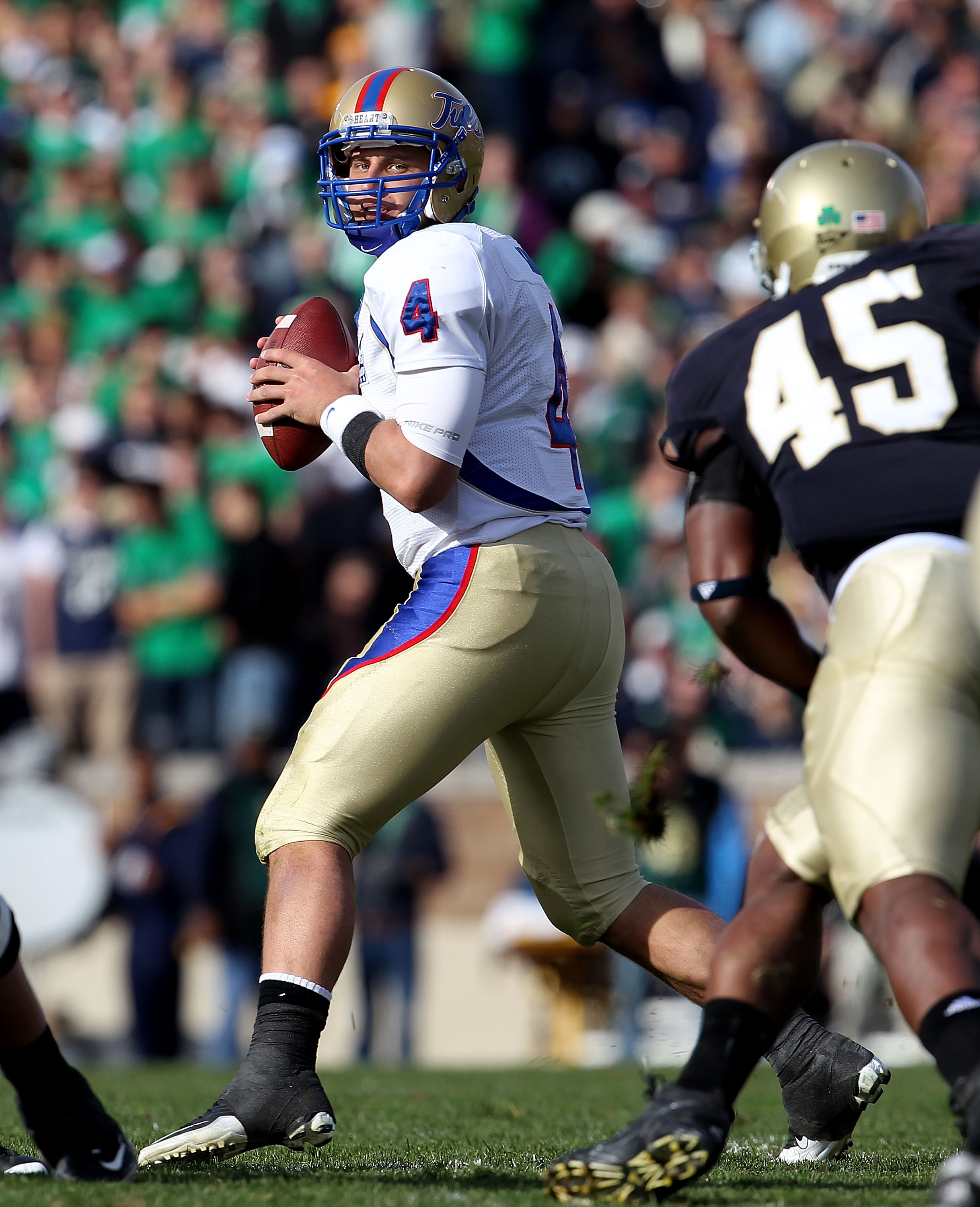 SOUTH BEND, IN - OCTOBER 30: G.J. Kinne #4 of the Tulsa Golden Hurricane looks to pass as Darius Flemming #45 of the Notre Dame Fighting Irish rushes at Notre Dame Stadium on October 30, 2010 in South Bend, Indiana. Tulsa defeated Notre Dame 28-27. (Photo