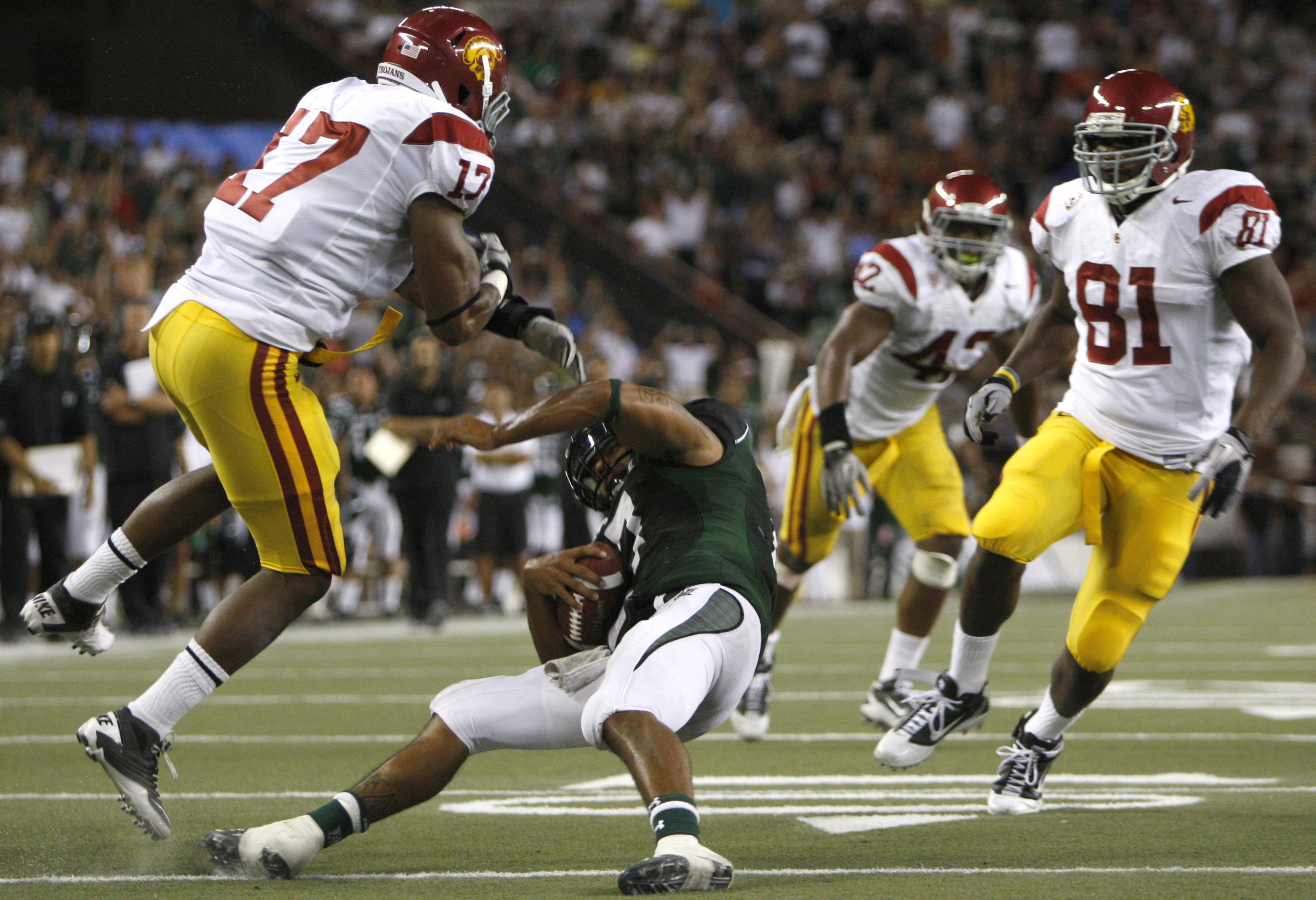 HONOLULU - SEPTEMBER 02: Bryant Moniz #17 of the University of Hawaii Warriors takes a hard hit from Michael Morgan #17 of the University of Southern California Trojans during second half action at Aloha Stadium September 2, 2010 in Honolulu, Hawaii. (Pho
