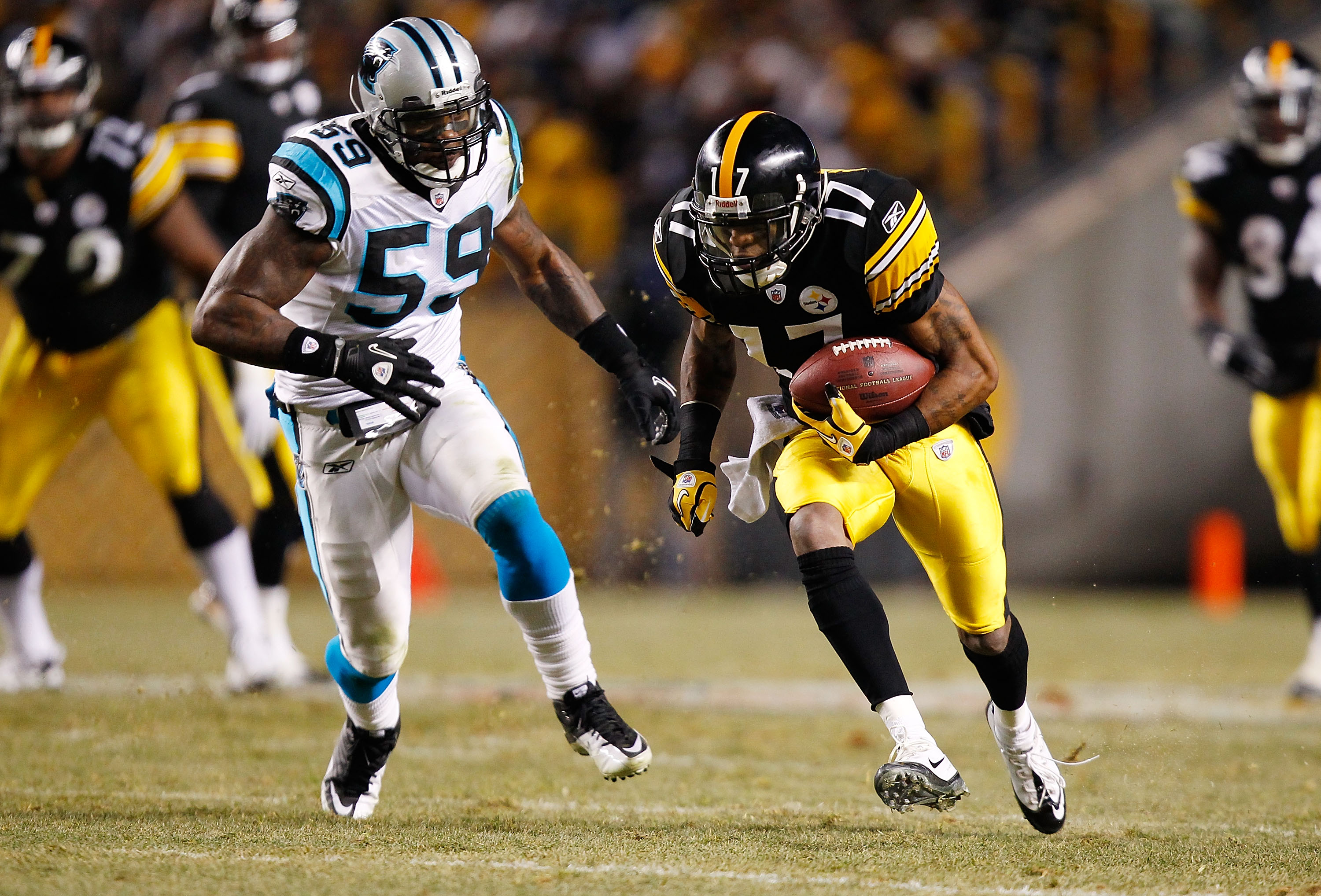 PITTSBURGH - DECEMBER 23:  Mike Wallace #17 of the Pittsburgh Steelers runs by Nic Harris #59 of the Carolina Panthers before scoring a touchdown during the game on December 23, 2010 at Heinz Field in Pittsburgh, Pennsylvania.  (Photo by Jared Wickerham/G