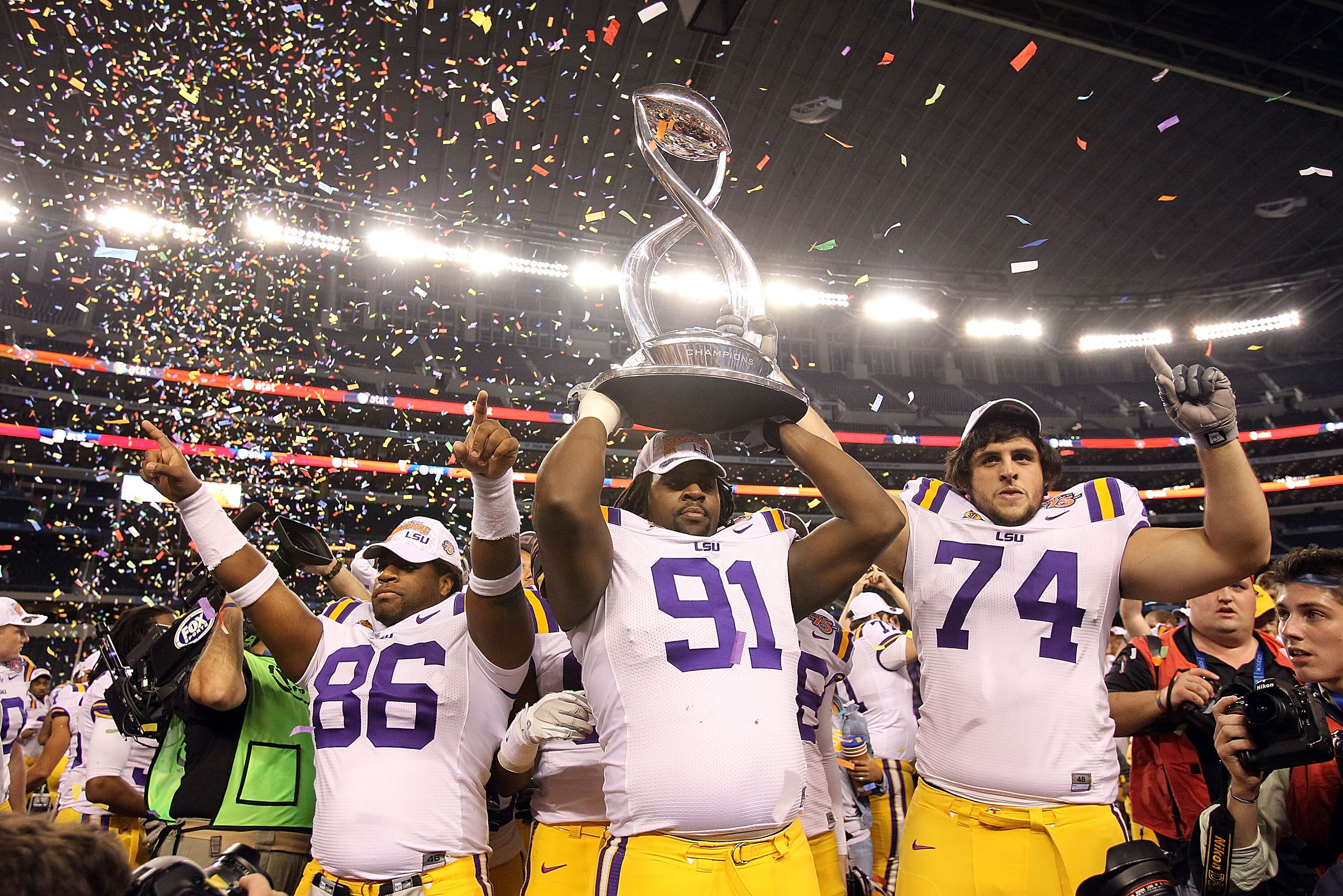 ARLINGTON, TX - JANUARY 07:  (L-R) Kadron Boone #86, Chris Davenport #91 and Josh Williford #74 of the LSU Tigers hold the trophy while celebrating a 41-24 win against the Texas A&M Aggies during the AT&T Cotton Bowl at Cowboys Stadium on January 7, 2011