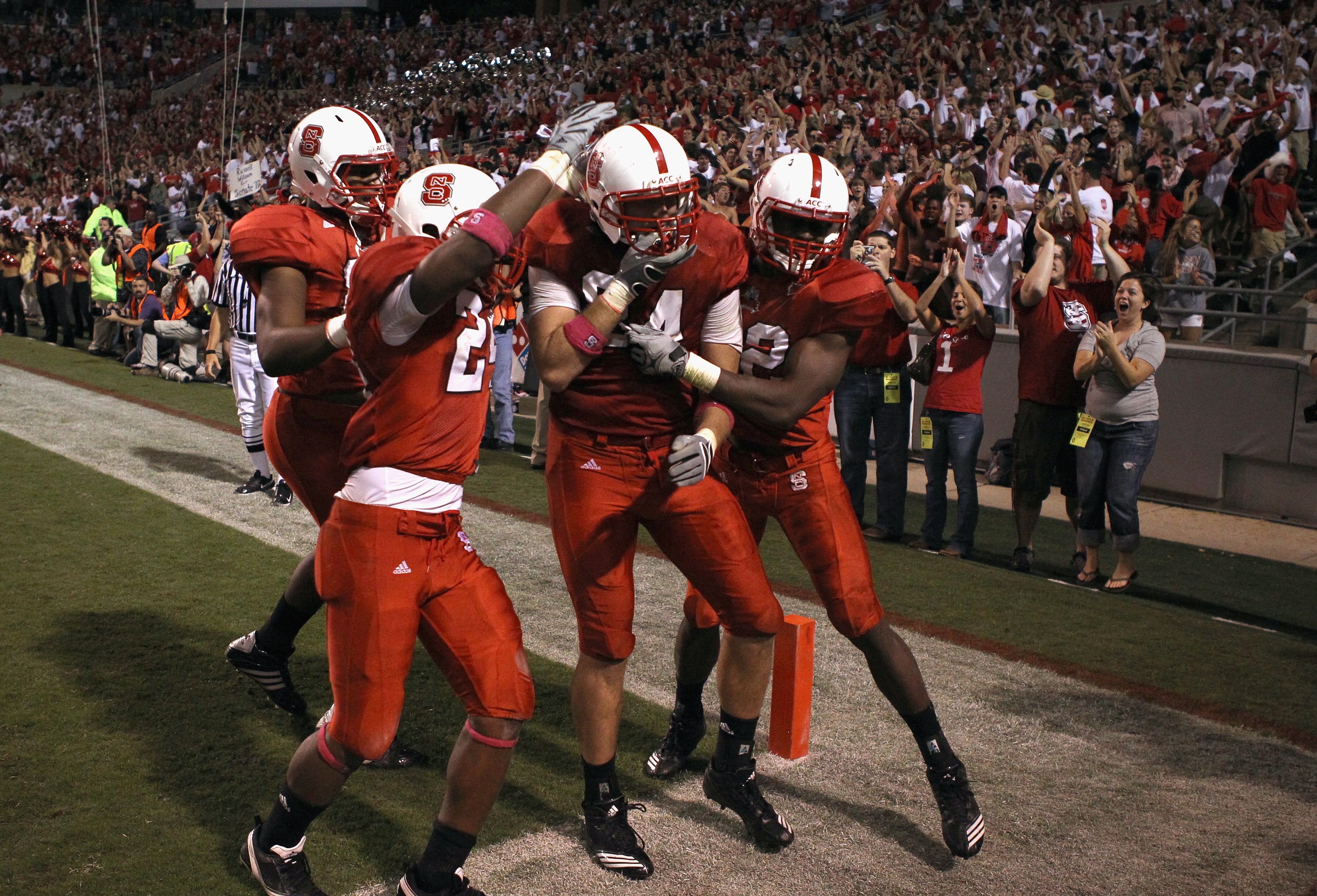 RALEIGH, NC - OCTOBER 28:  George Bryan #84 of the North Carolina State Wolfpack celebrates with teammates after a game winning touchdown and defeating the Florida State Seminoles 28-24 during their game at Carter-Finley Stadium on October 28, 2010 in Ral