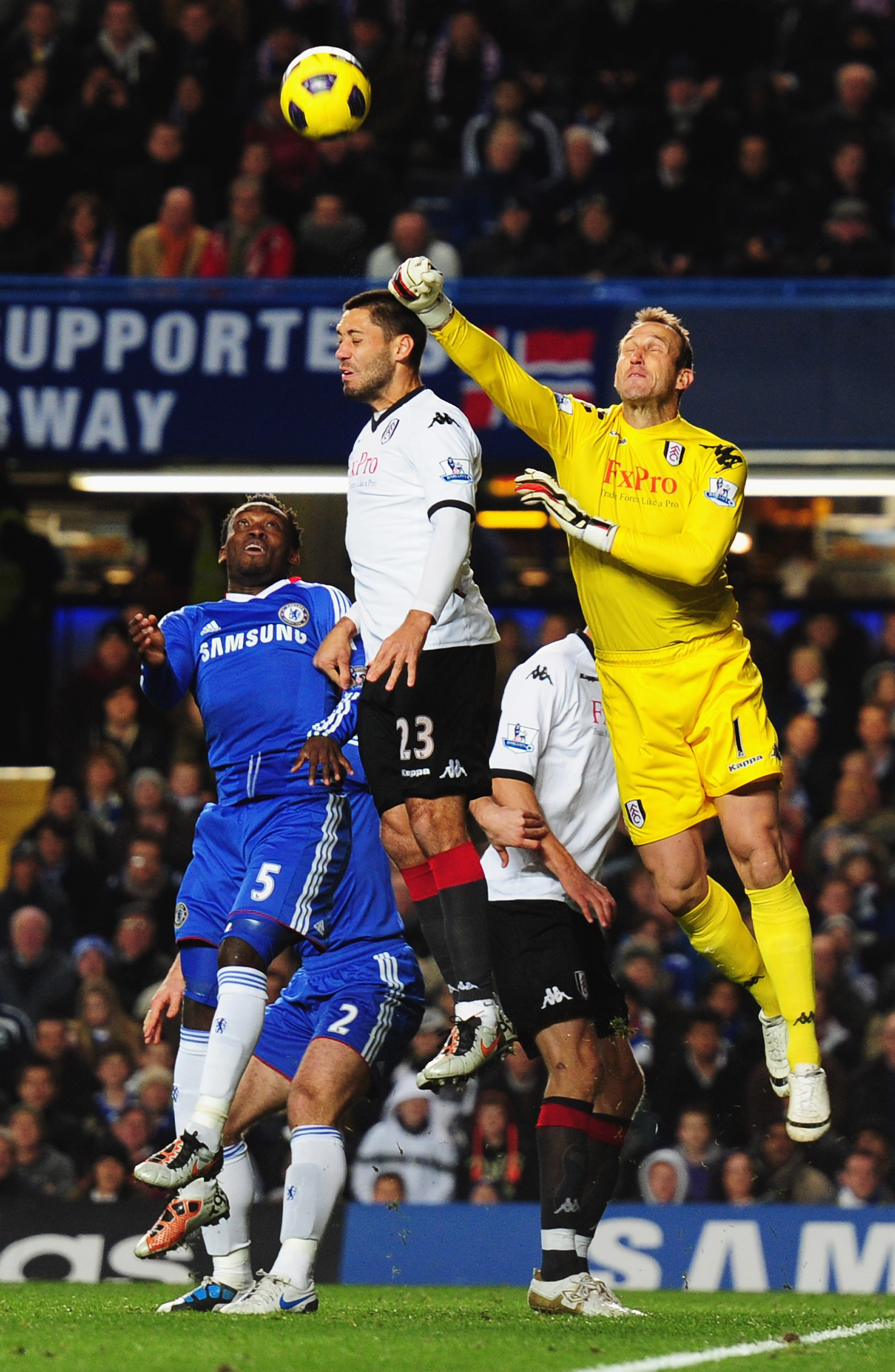 LONDON, ENGLAND - NOVEMBER 10:  Clint Dempsey (23) and Mark Schwarzer of Fulham foil Michael Essien of Chelsea during the Barclays Premier League match between Chelsea and Fulham at Stamford Bridge on November 10, 2010 in London, England.  (Photo by Mike