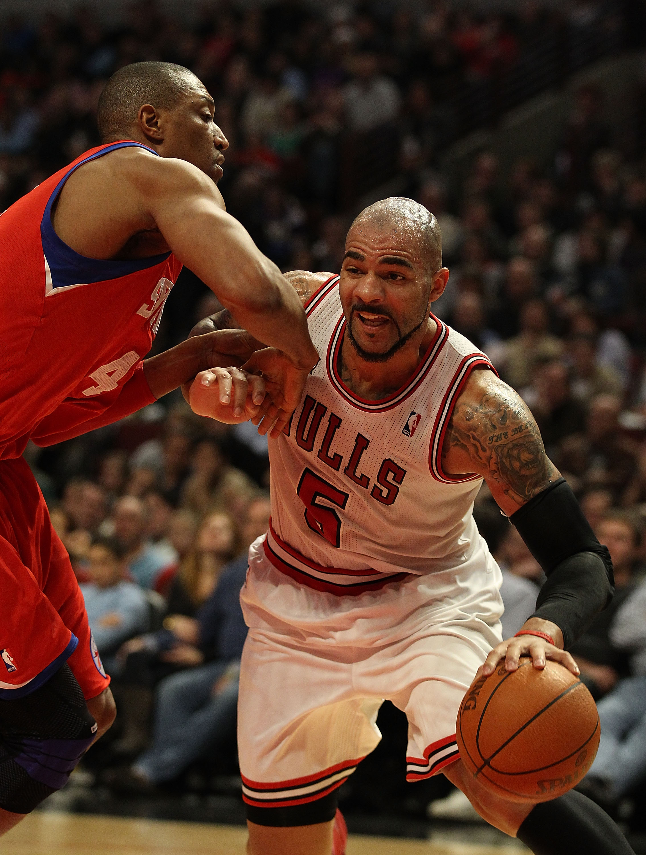 CHICAGO, IL - DECEMBER 21: Carlos Boozer #5 of the Chicago Bulls drives against Tony Battie #4 of the Philadelphia 76ers at the United Center on December 21, 2010 in Chicago, Illinois. The Bulls defeated the 76ers 121-76. NOTE TO USER: User expressly ackn