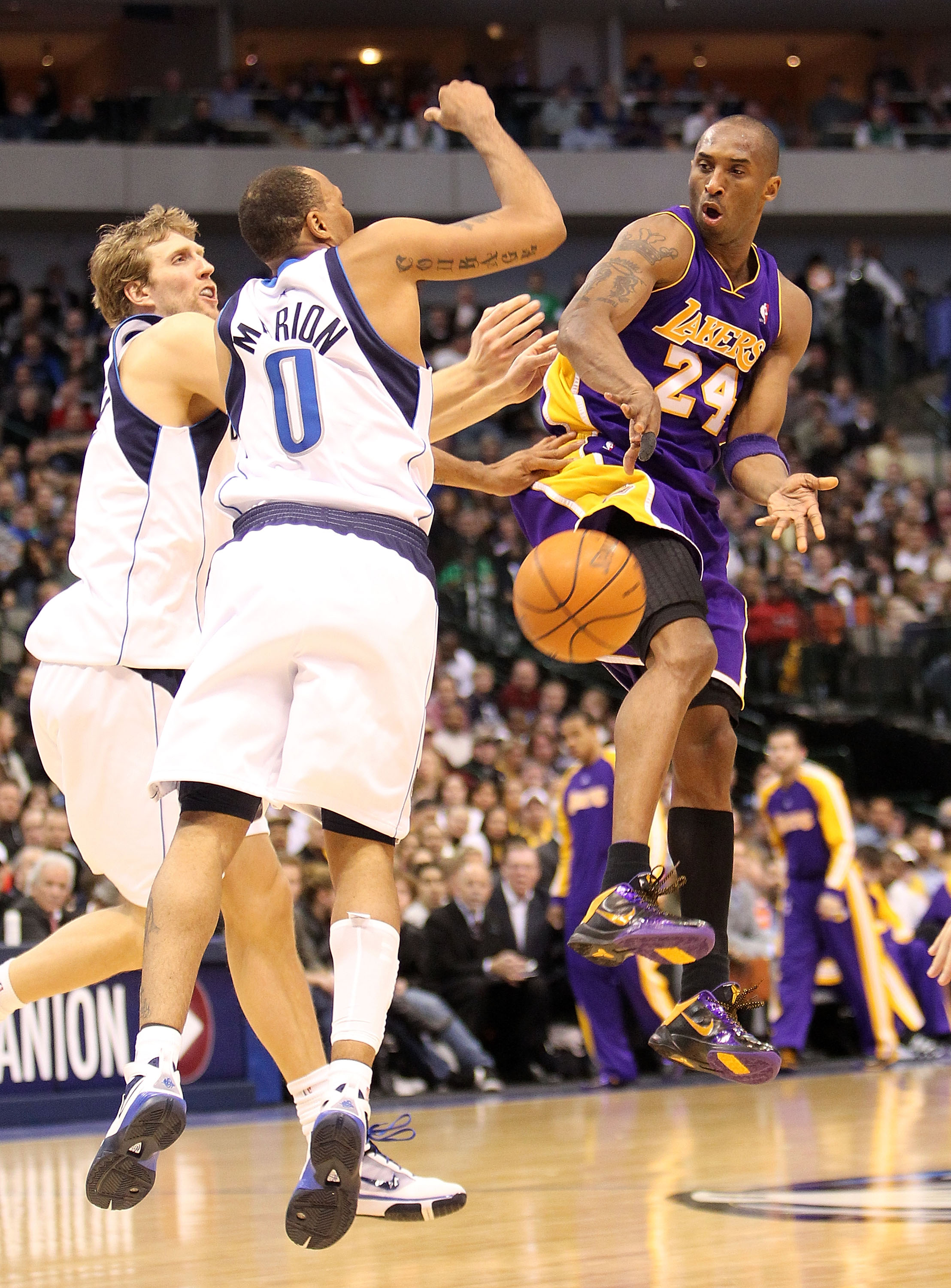 DALLAS - FEBRUARY 24:  Kobe Bryant #24 of the Los Angeles Lakers passes against Dirk Nowitzki #41 and Shawn Marion #0 of the Dallas Mavericks on February 24, 2010 at American Airlines Center in Dallas, Texas.  NOTE TO USER: User expressly acknowledges and