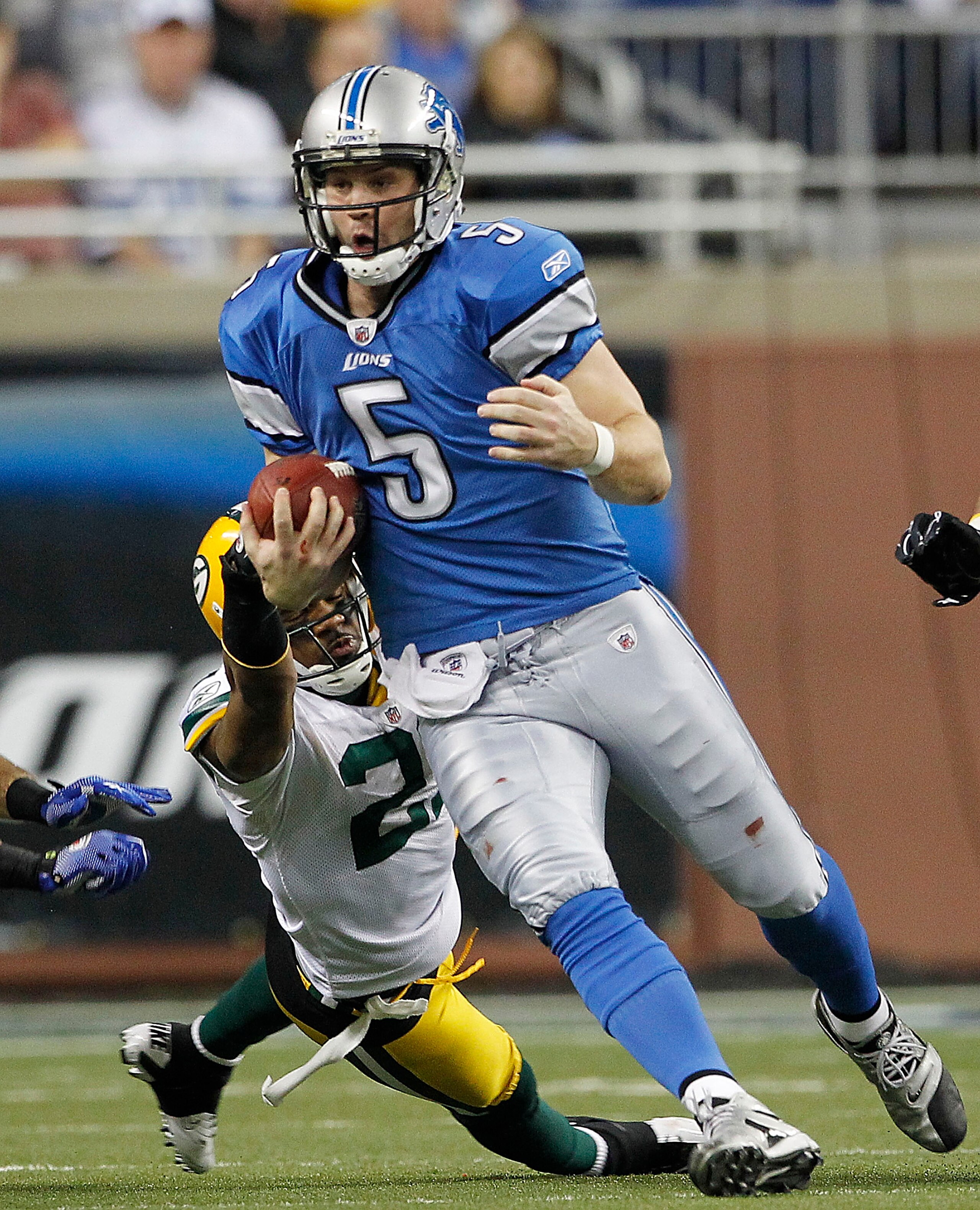 DETROIT - DECEMBER 12: Drew Stanton #5 of the Detroit Lions runs for a first down as Charles Woodson #21 of the Green Bay Packers attempts to make the stop during the game at Ford Field on December 12, 2010 in Detroit, Michigan. The Lions defeated the Pac