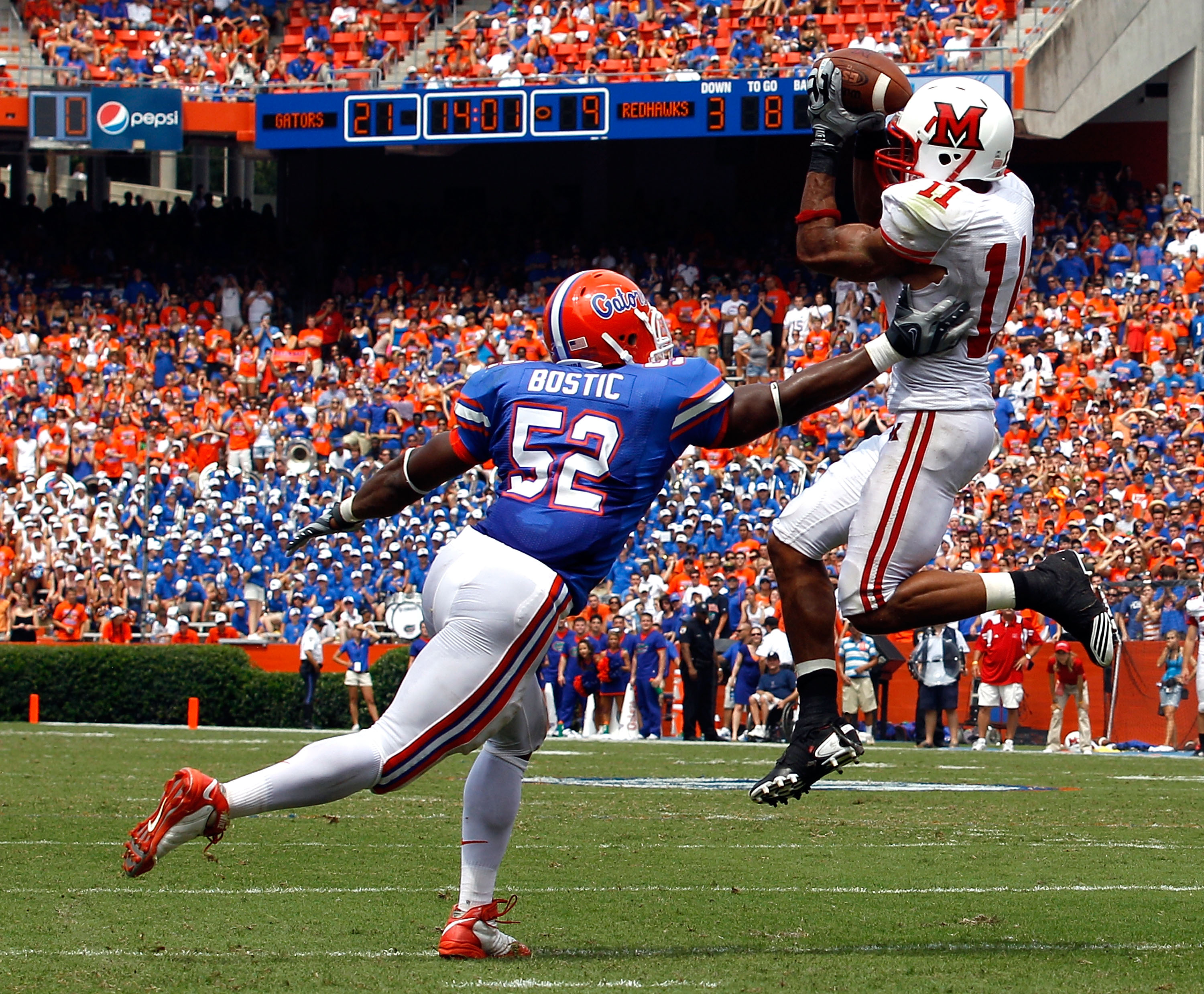 GAINESVILLE, FL - SEPTEMBER 04: Armand Robinson #11 of Miami University RedHawks catches a pass against Jonathan Bostic #52 of the Florida Gators at Ben Hill Griffin Stadium on September 4, 2010 in Gainesville, Florida. (Photo by Sam Greenwood/Getty Ima