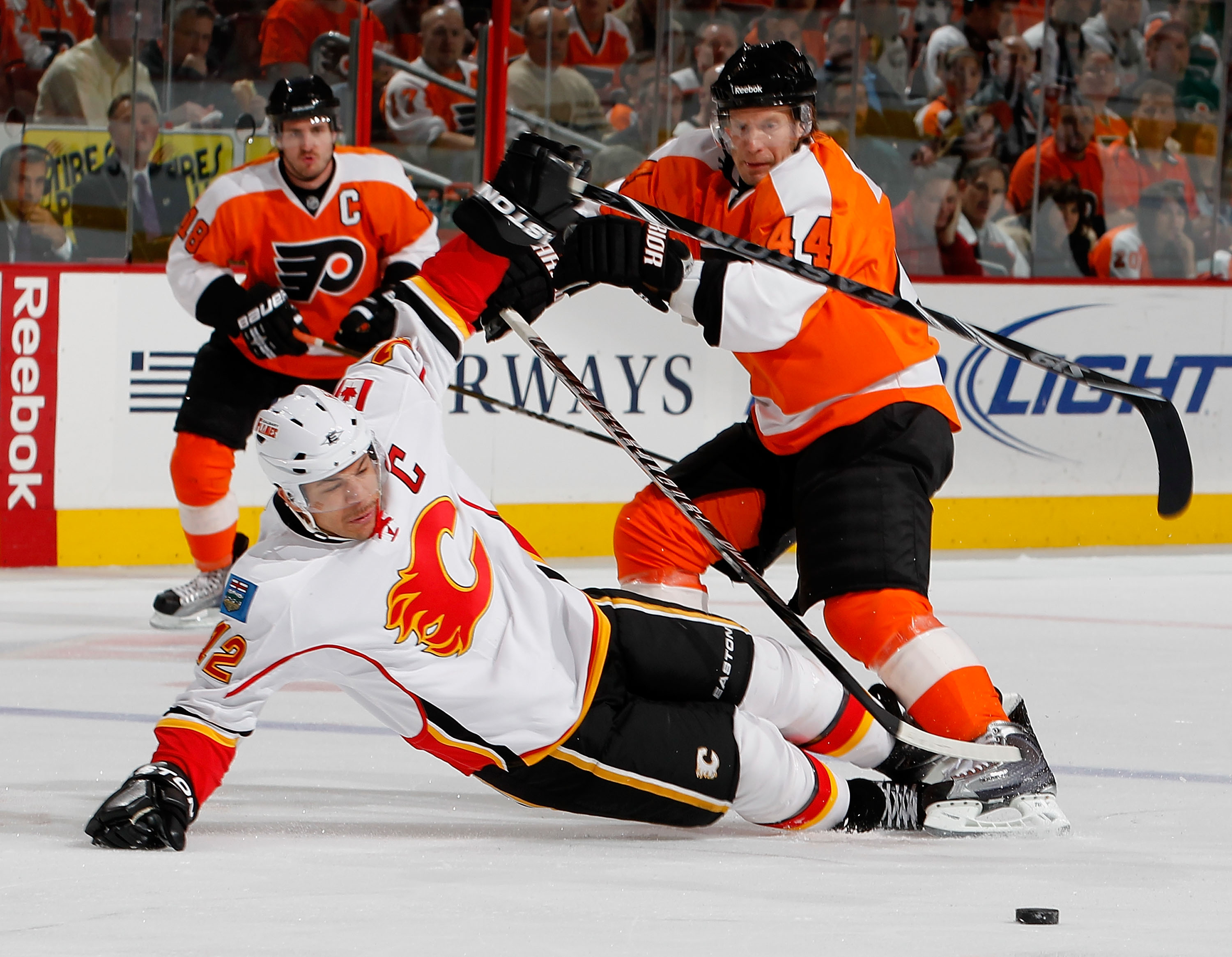 PHILADELPHIA - NOVEMBER 26:  Jarome Iginla #12 of the Calgary Flames is knocked to the ice by Kimmo Timonen #44 of the Philadelphia Flyers during the first period of a hockey game at the Wells Fargo Center on November 26, 2010 in Philadelphia, Pennsylvani