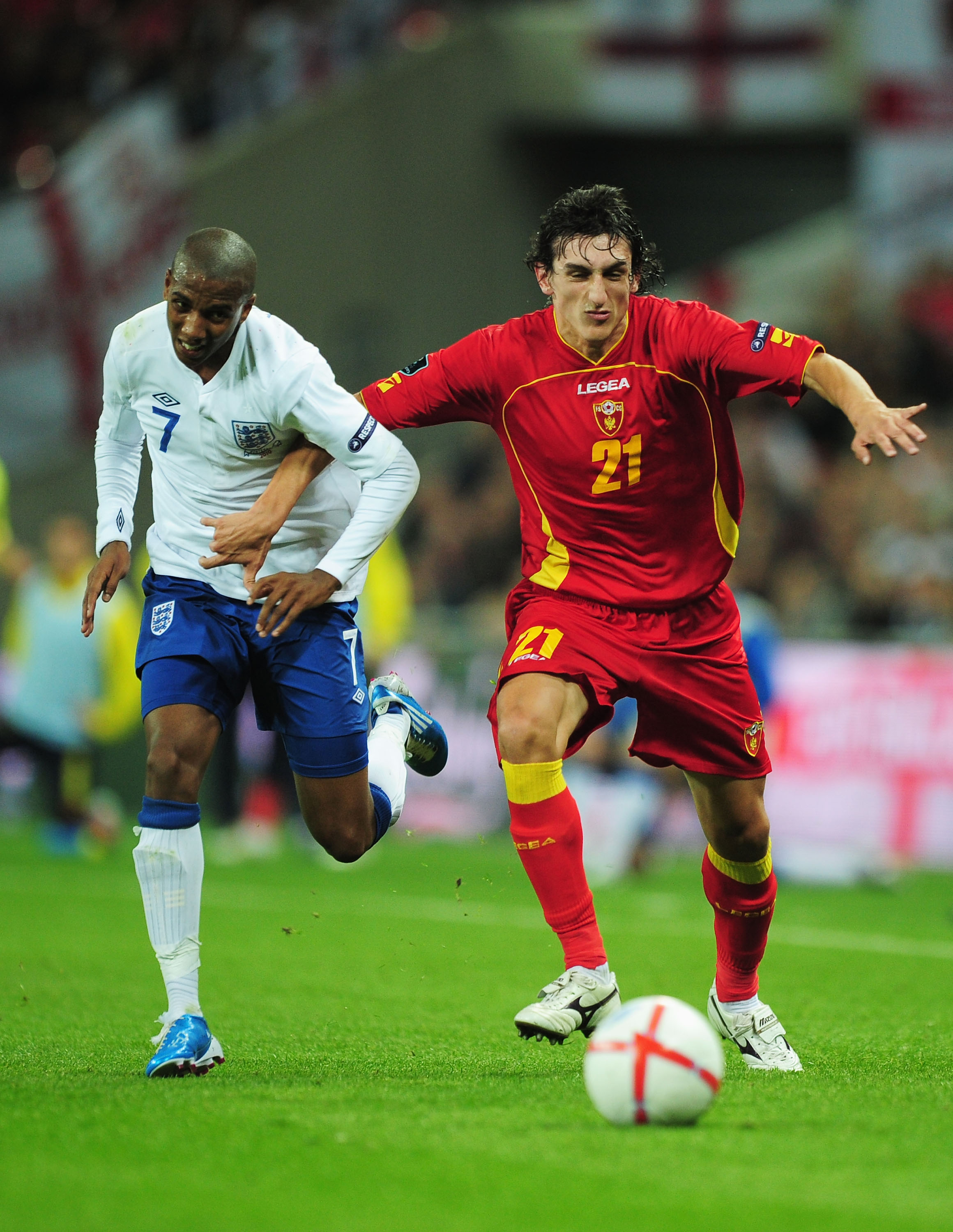 LONDON, ENGLAND - OCTOBER 12:  Ashley Young of England and Stefan Savic of Montenegro battle for the ball during the UEFA EURO 2012 Group G Qualifying match between England and Montenegro at Wembley Stadium on October 12, 2010 in London, England.  (Photo