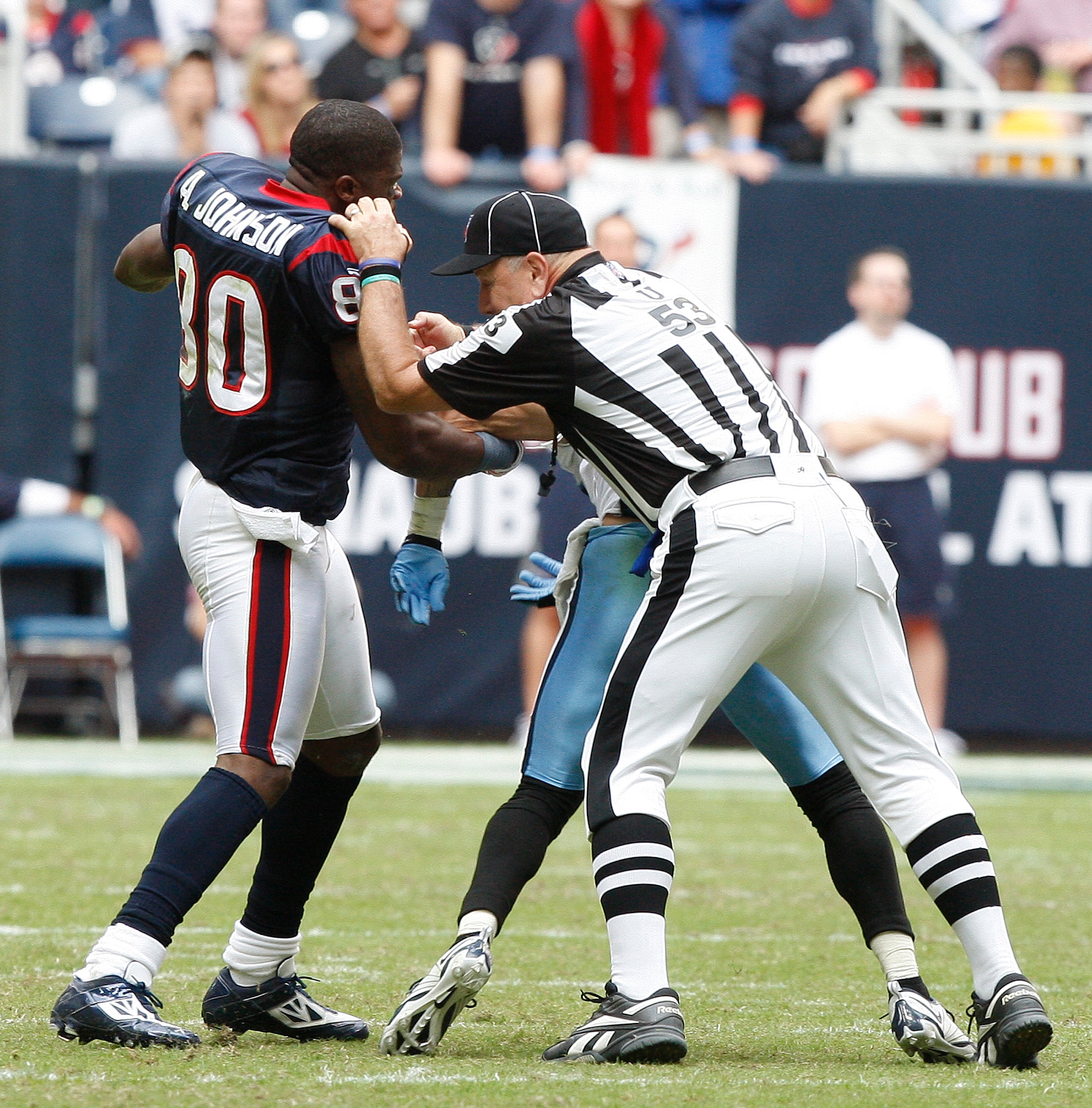 HOUSTON - NOVEMBER 28:  Wide receiver Andre Johnson #80 of the Houston Texans is separated by umpire Garth DeFerlice #53 from cornerback Cortland Finnegan #31 of the Tennessee Titans after the two exchanged punches in the fourth quarter at Reliant Stadium