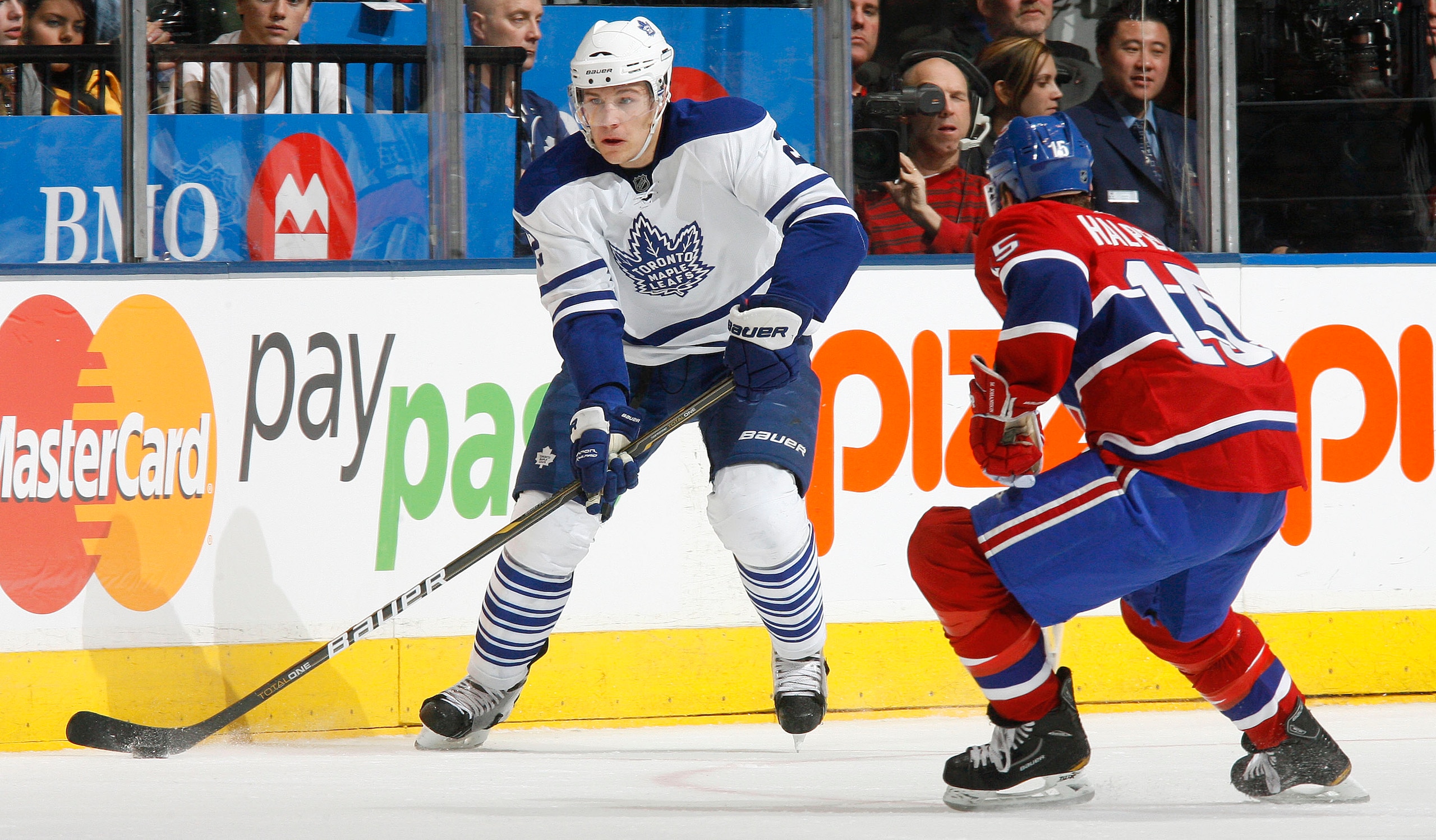 TORONTO - DECEMBER 11:  Luke Schenn #2 of the Toronto Maple Leafs carries the puck as Jeff Halpern #15 of the Montreal Canadiens defends during their NHL game at Air Canada Centre on December 11, 2010 in Toronto, Ontario, Canada.(Photo By Dave Sandford/Ge