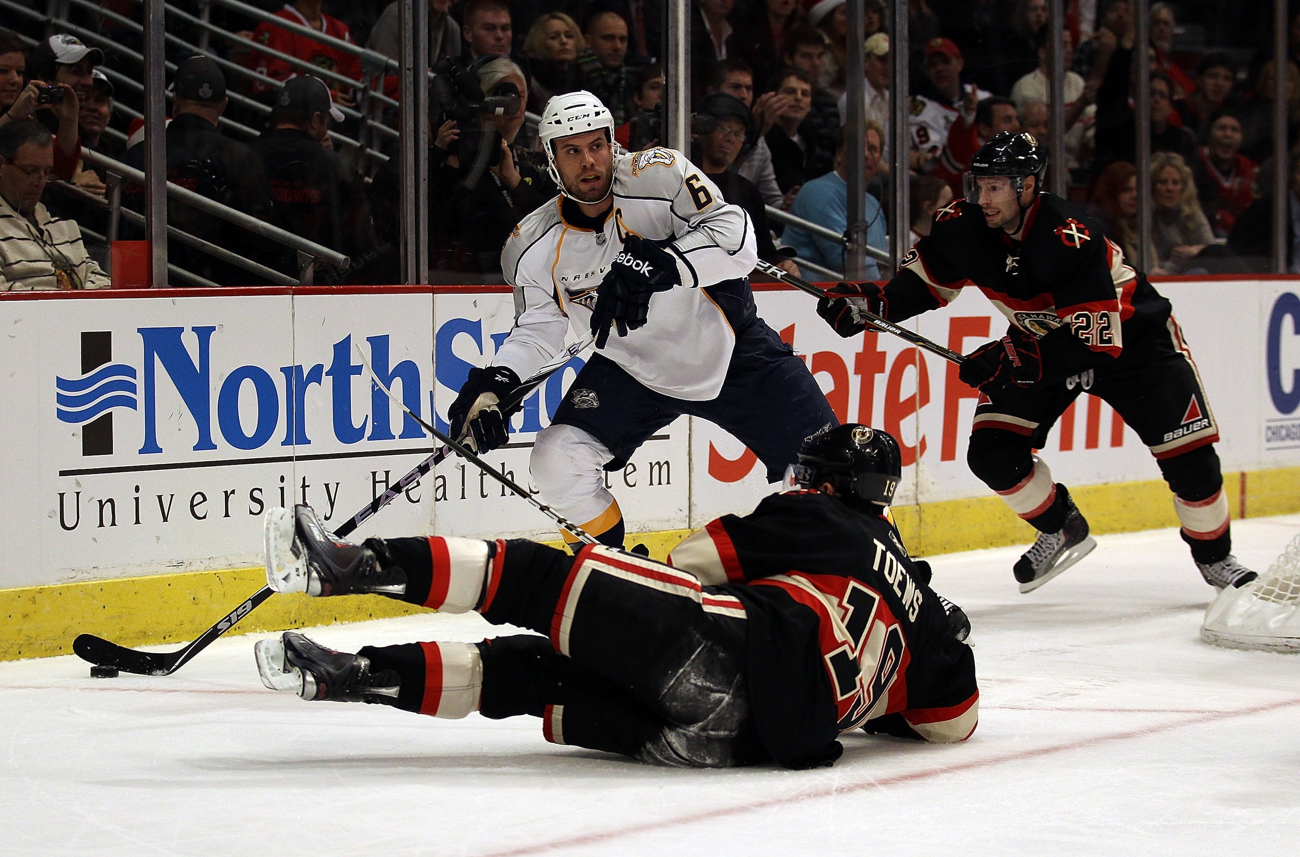 CHICAGO, IL - DECEMBER 22: Shea Weber #6 of the Nashville Predators looks to pass after knocking down Jonathan Toews #19 of the Chicago Blackhawks behind the Predators net as Troy Brouwer #22 skates to the puck at the United Center on December 22, 2010 in