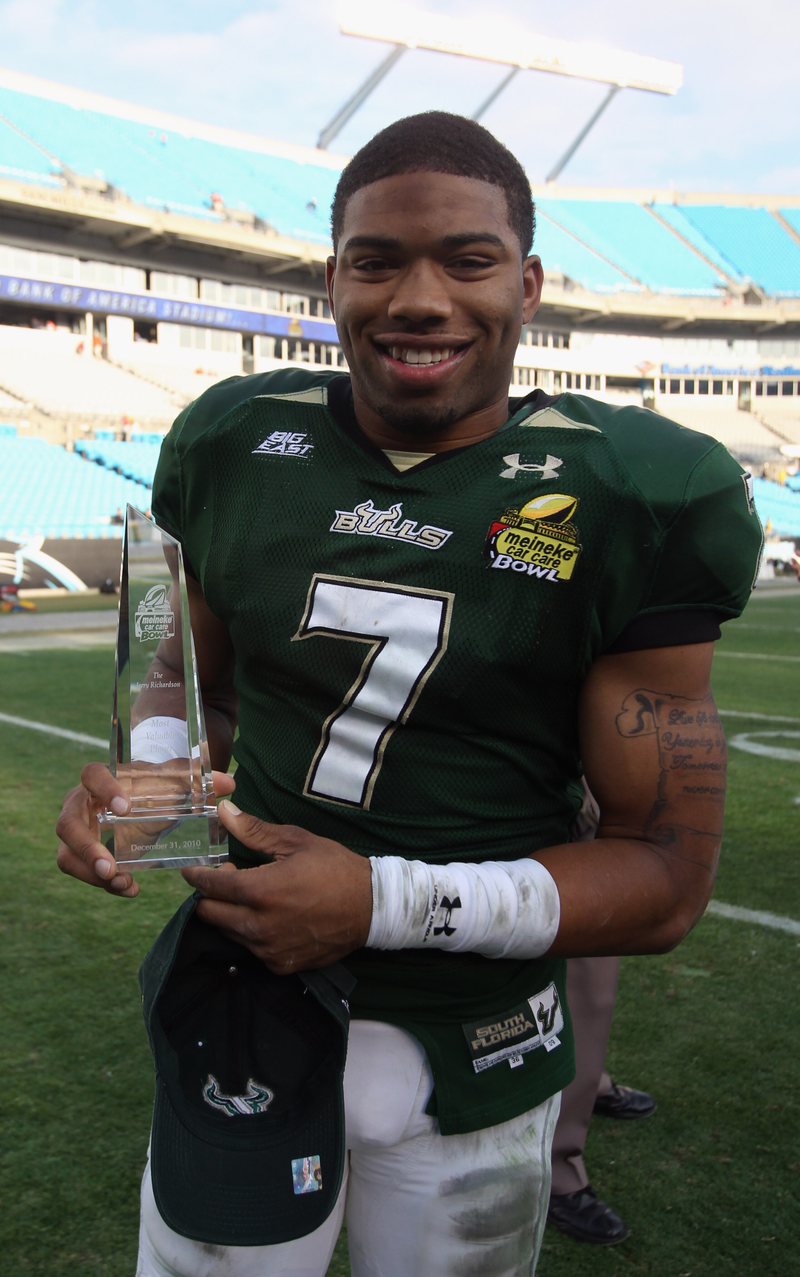 CHARLOTTE, NC - DECEMBER 31:  B.J. Daniels #7 of the USF Bulls stands with the MVP trophy after a 31-26 victory over the Clemson Tigers at Bank of America Stadium on December 31, 2010 in Charlotte, North Carolina.  (Photo by Streeter Lecka/Getty Images)