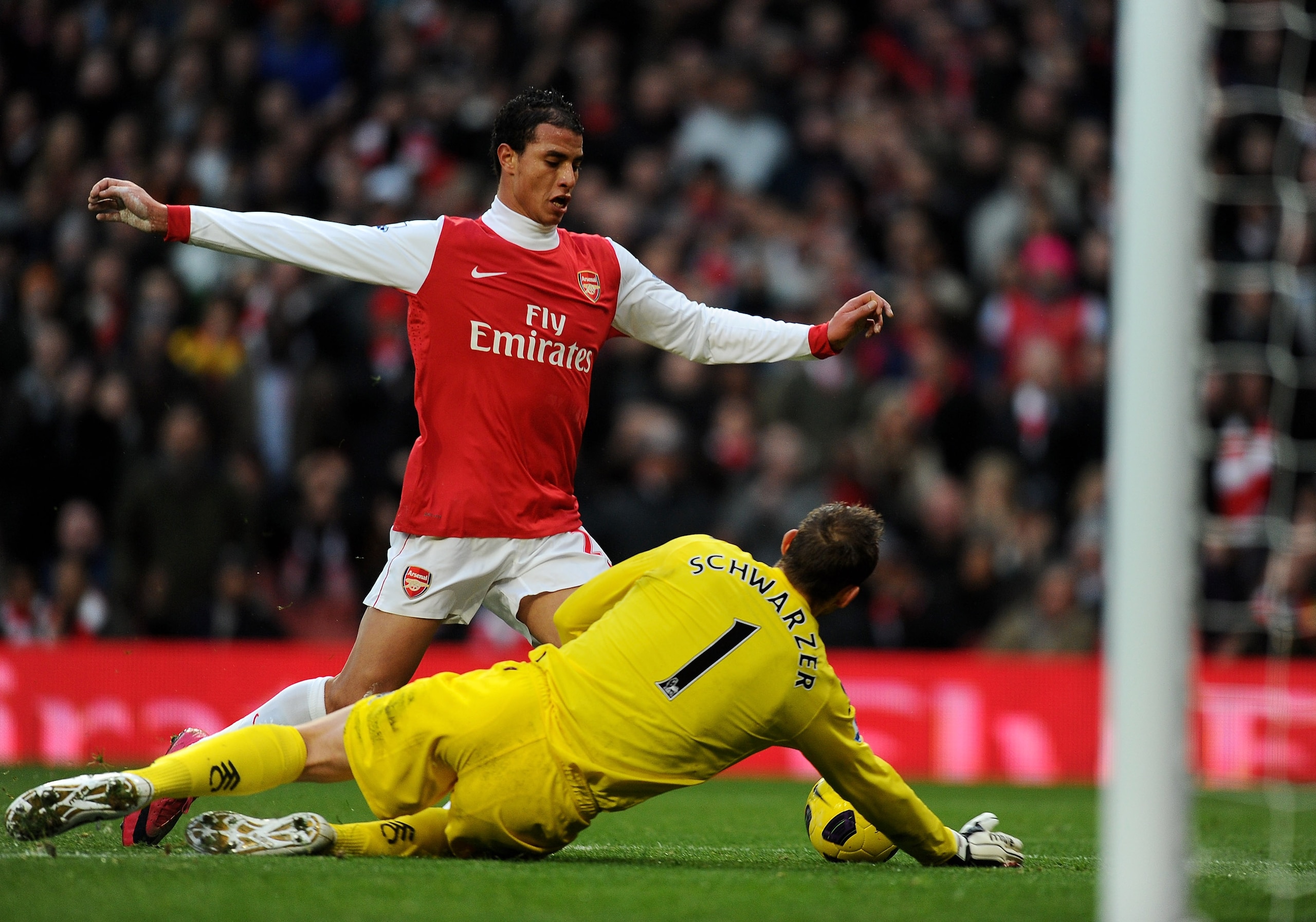 LONDON, ENGLAND - DECEMBER 04:  Marouane Chamakh (up) of Arsenal is tackled by Mark Schwarzer of Fulham during the Barclays Premier League match between Arsenal and Fulham at the Emirates Stadium on December 4, 2010 in London, England.  (Photo by Mike Hew