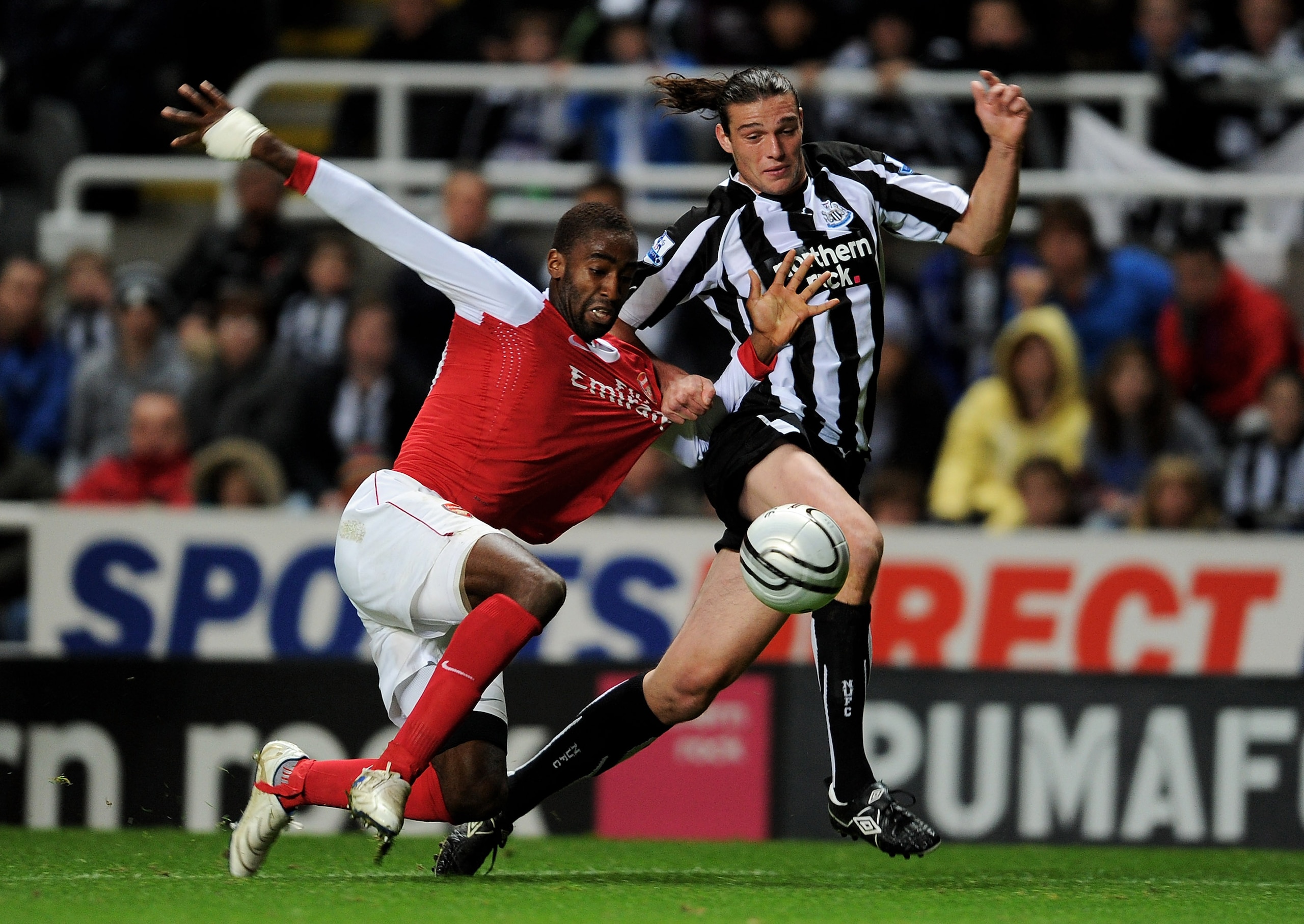 NEWCASTLE UPON TYNE, ENGLAND - OCTOBER 27:  Andy Carroll of Newcastle United tangles with Johan Djourou of Arsenal during the Carling Cup Fourth Round match between Newcastle United and Arsenal at St James' Park on October 27, 2010 in Newcastle, England.