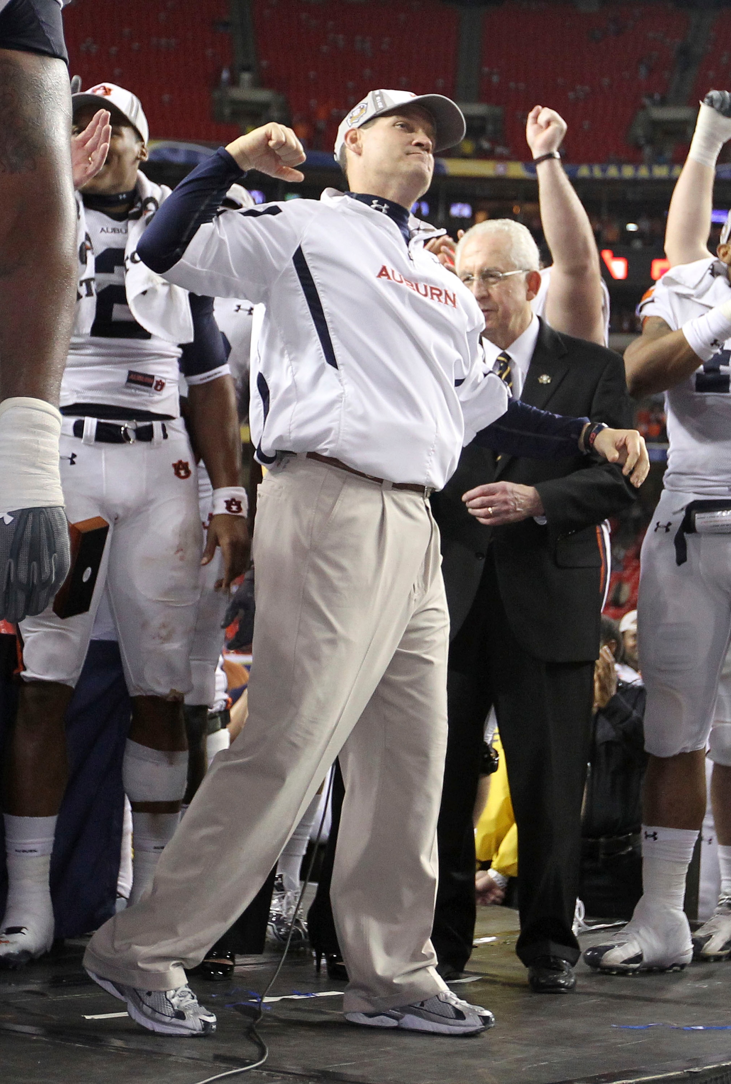 ATLANTA - DECEMBER 4:  Head coach Gene Chizik of the Auburn Tigers celebrates on the podium after the 2010 SEC Championship against the South Carolina Gamecocks at Georgia Dome on December 4, 2010 in Atlanta, Georgia. The Tigers beat the Gamecocks 56-17.