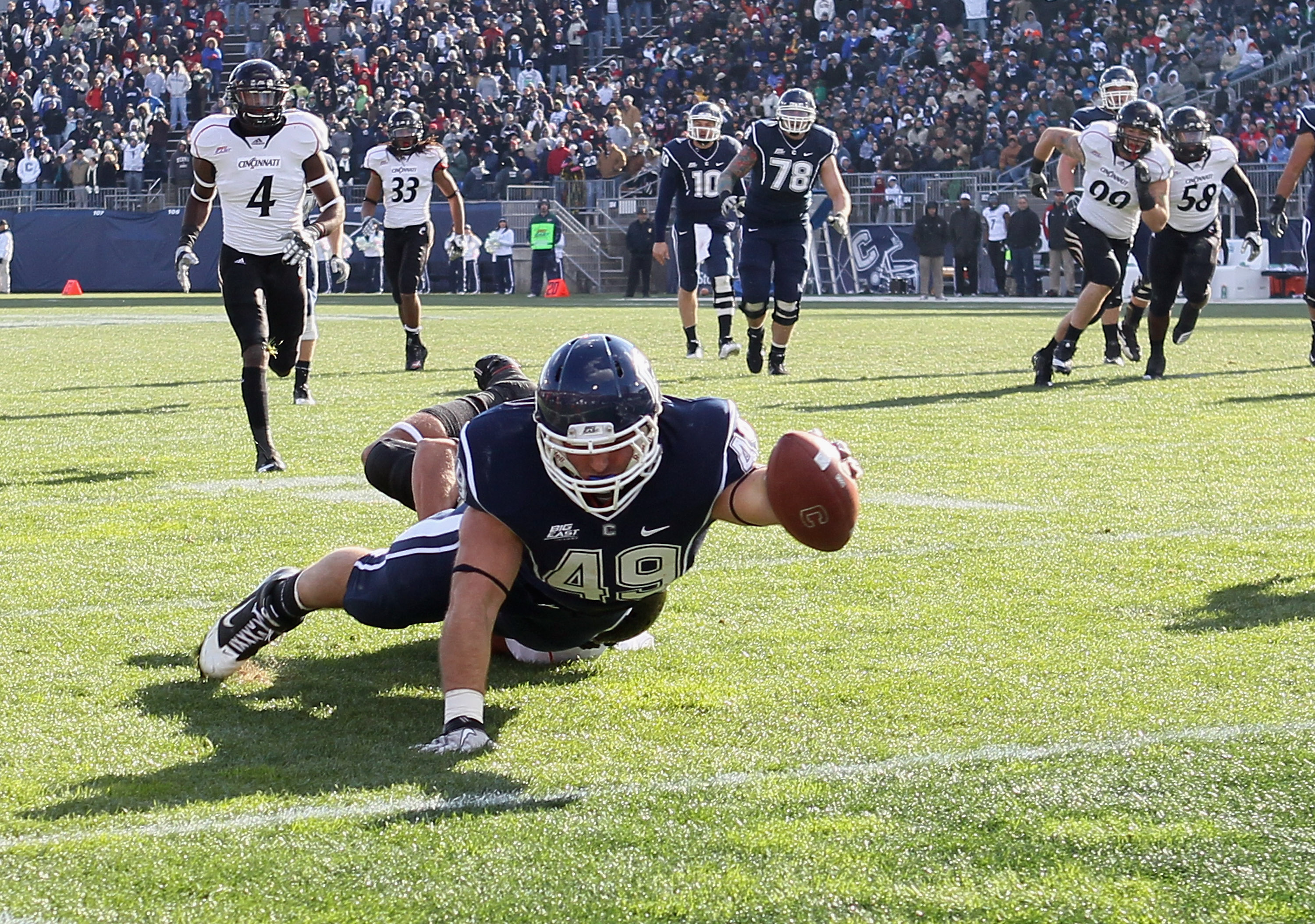 EAST HARTFORD, CT - NOVEMBER 27: Anthony Sherman #49 of the Connecticut Huskies scores a touchdown as Wesley Richardson #24 of the Cincinnati Bearcats defends on November 27, 2010 at Rentschler Field in East Hartford, Connecticut. (Photo by Elsa/Getty I