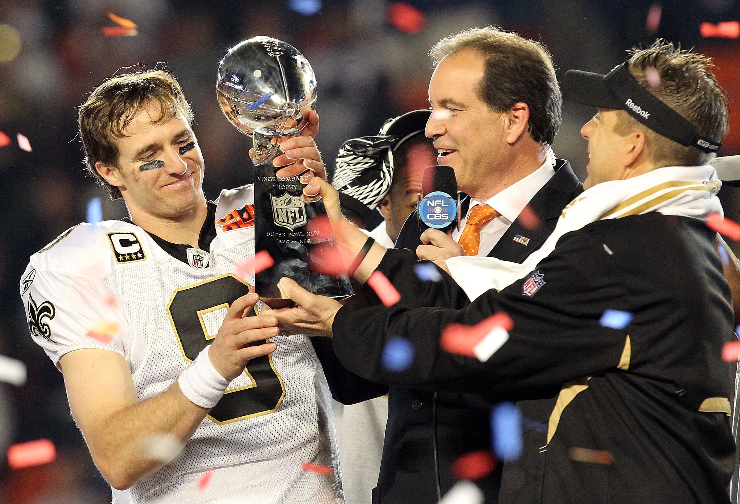 MIAMI GARDENS, FL - FEBRUARY 07:  Head coach Sean Payton of the New Orleans Saints passes quarterback Drew Brees #9 the Vince Lombardi trophy after defeating the Indianapolis Colts during Super Bowl XLIV on February 7, 2010 at Sun Life Stadium in Miami Ga