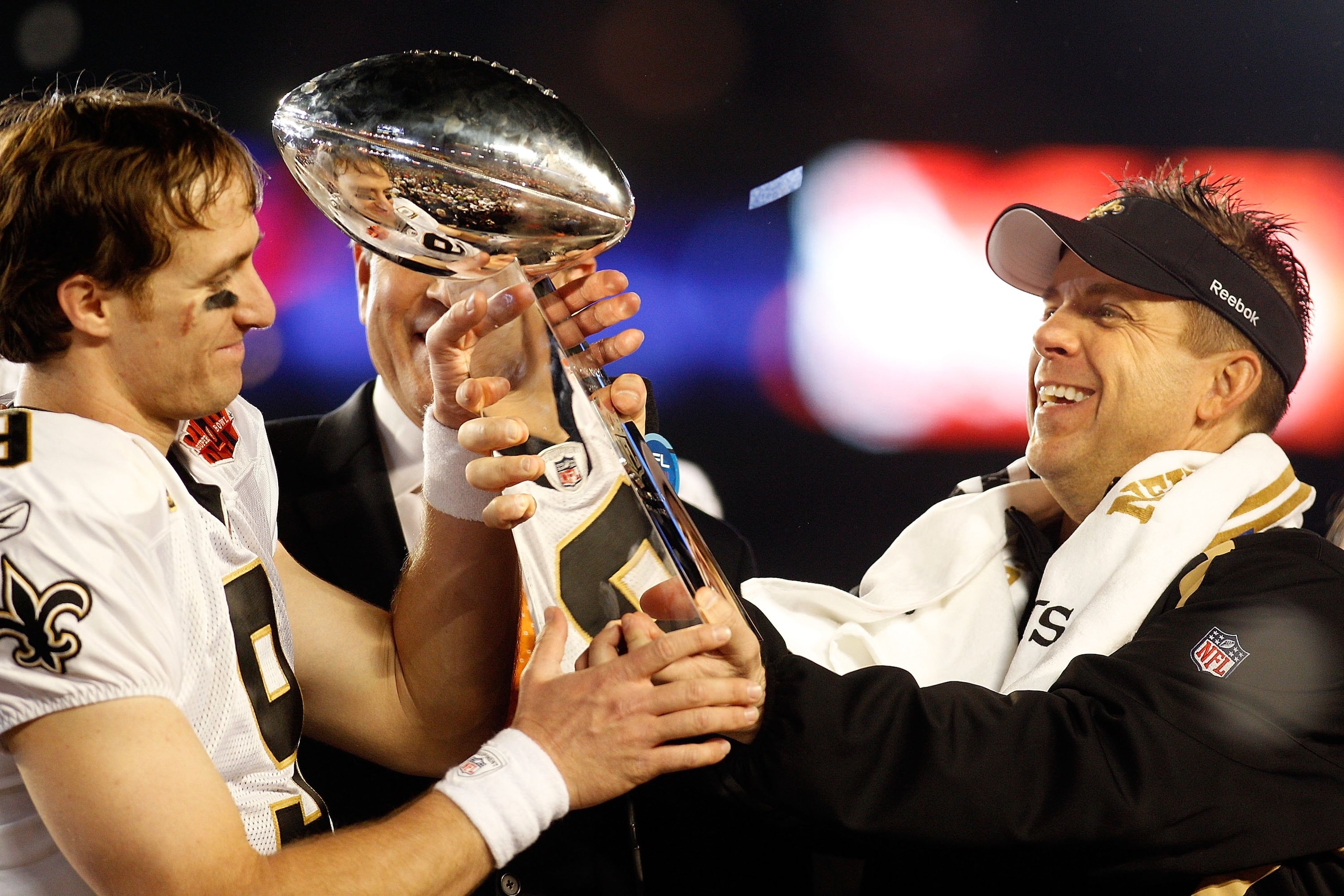 MIAMI GARDENS, FL - FEBRUARY 07:  Head coach Sean Payton of the New Orleans Saints hands quarterback Drew Brees #9 the Vince Lombardi trophy after defeating the Indianapolis Colts during Super Bowl XLIV on February 7, 2010 at Sun Life Stadium in Miami Gar