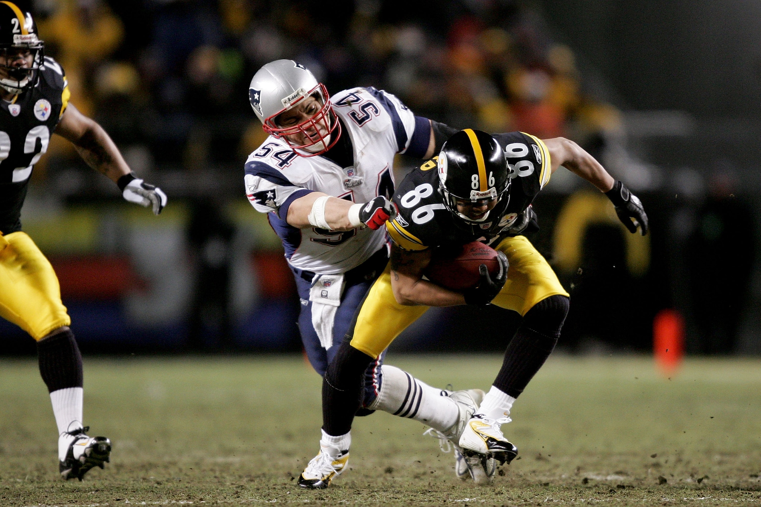 PITTSBURGH - JANUARY 23: Tedy Bruschi #54 of the New England Patriots pulls down Hines Ward #86 of the Pittsburgh Steelers in the AFC championship game at Heinz Field on January 23, 2005 in Pittsburgh, Pennsylvania.  The Patriots defeated the Steelers 41-