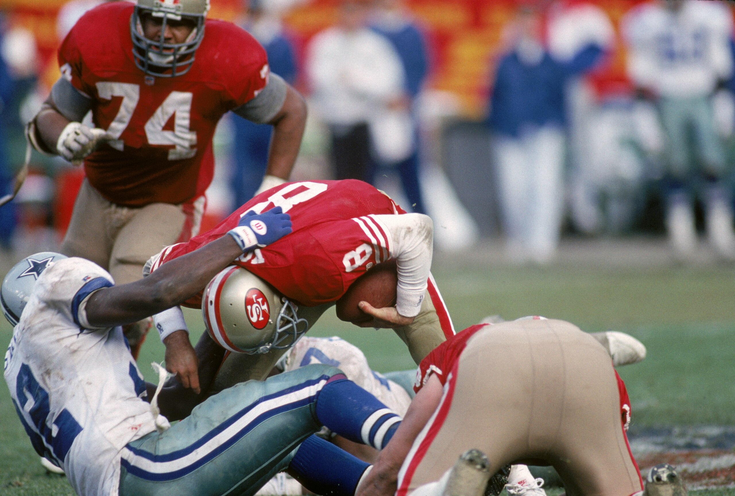 SAN FRANCISCO - JANUARY 17:  Quarterback Steve Young #8 of the San Francisco 49ers attempts to break the grasp of defensive end Tony Tolbert #92 of the Dallas Cowboys during the 1992 NFC Championship Game at Candlestick Park on January 17, 1993 in San Fra